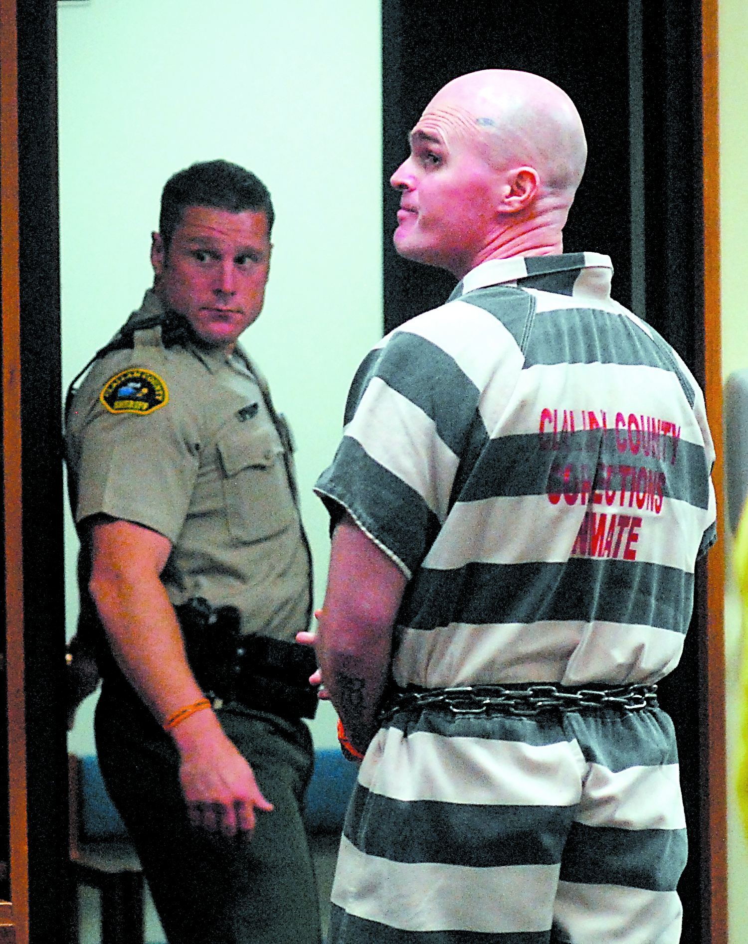 Patrick Drum looks back at the courtroom after his sentencing in Clallam County Superior Court in Port Angeles on Tuesday. Looking on at left is court security officer Eric Morris. Keith Thorpe/Peninsula Daily News