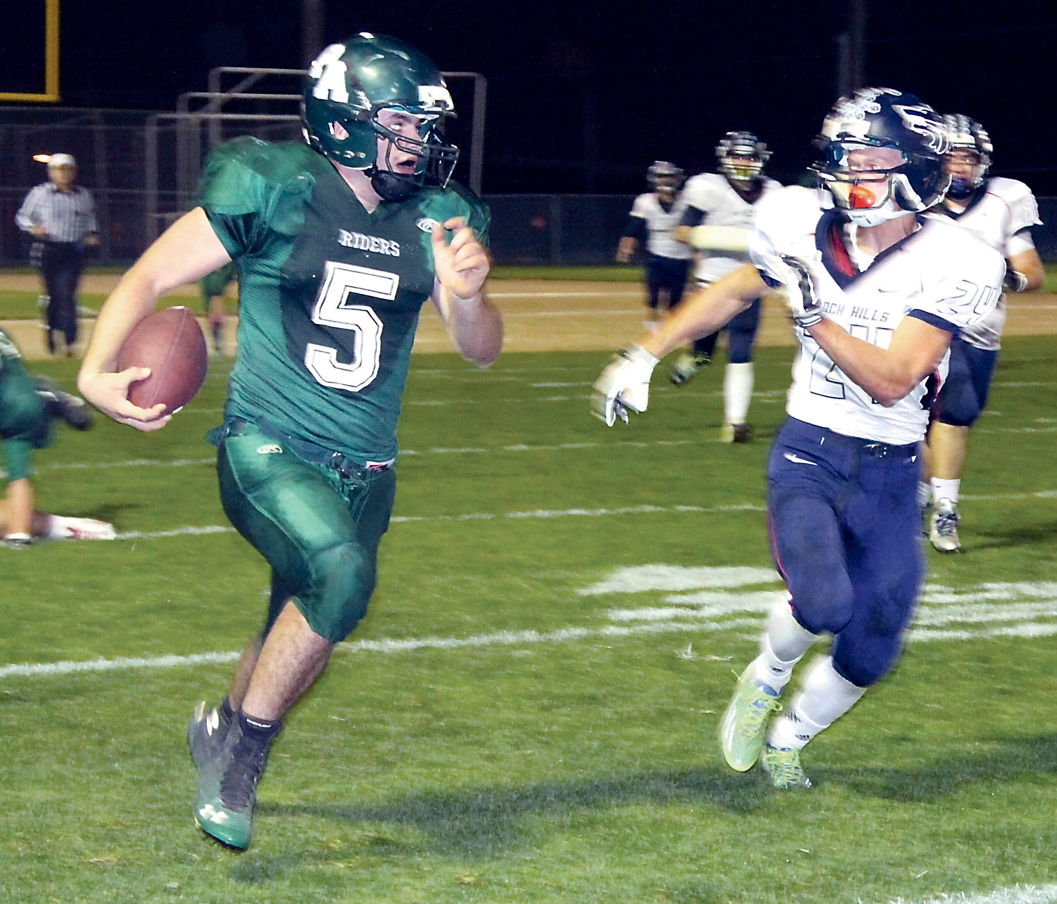 Port Angeles' Nathan Angevine (5) runs upfield for a 30-yard gain off a short swing pass in the third quarter as Black Hills' Josh Boyd tries to chase him down. Dave Logan/Peninsula Daily News