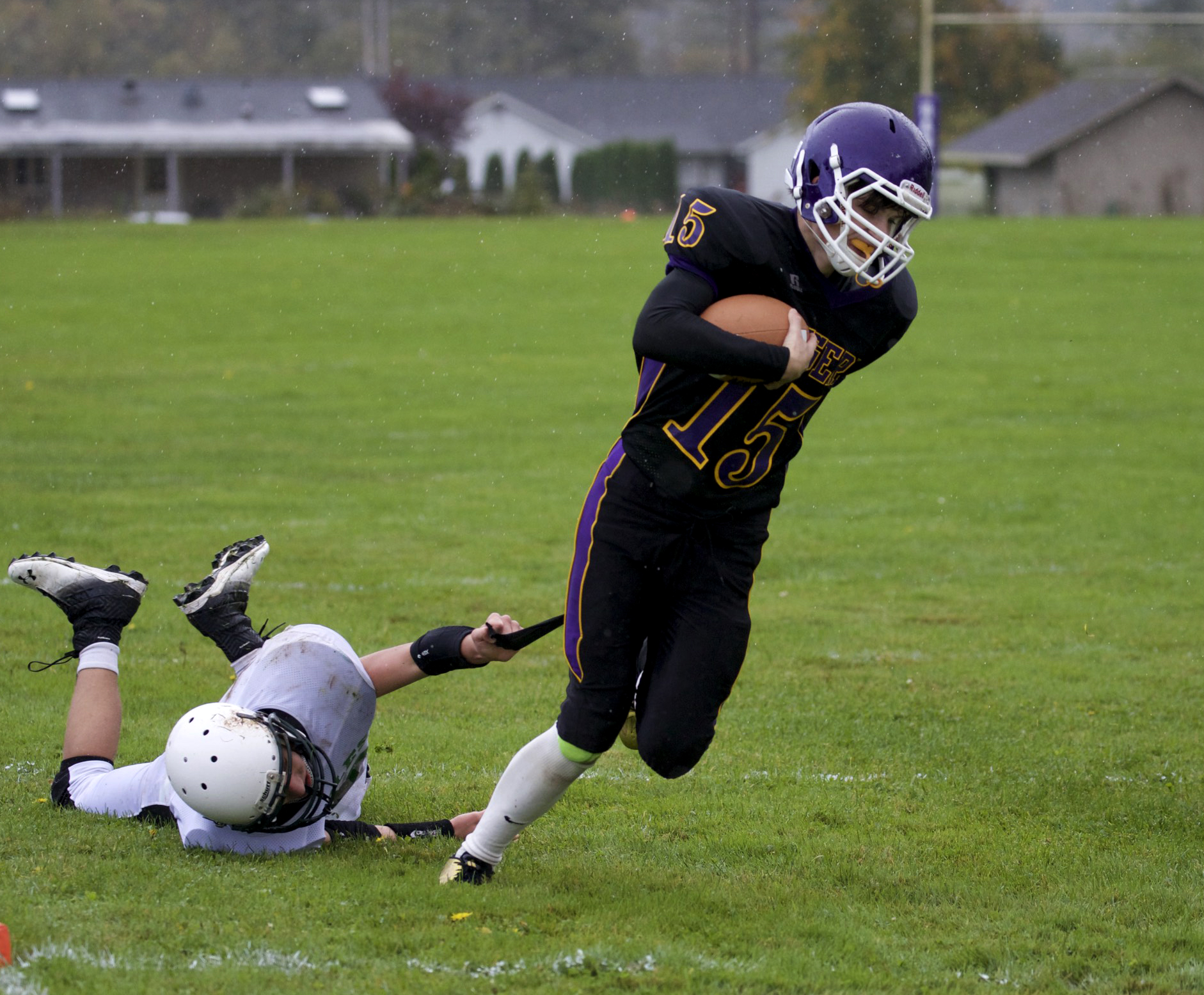 Quilcene quarterback Eli Harrison breaks away from Evergreen Lutheran's Ryan Lorette but loses a piece of his uniform. Steve Mullensky/for Peninsula Daily News