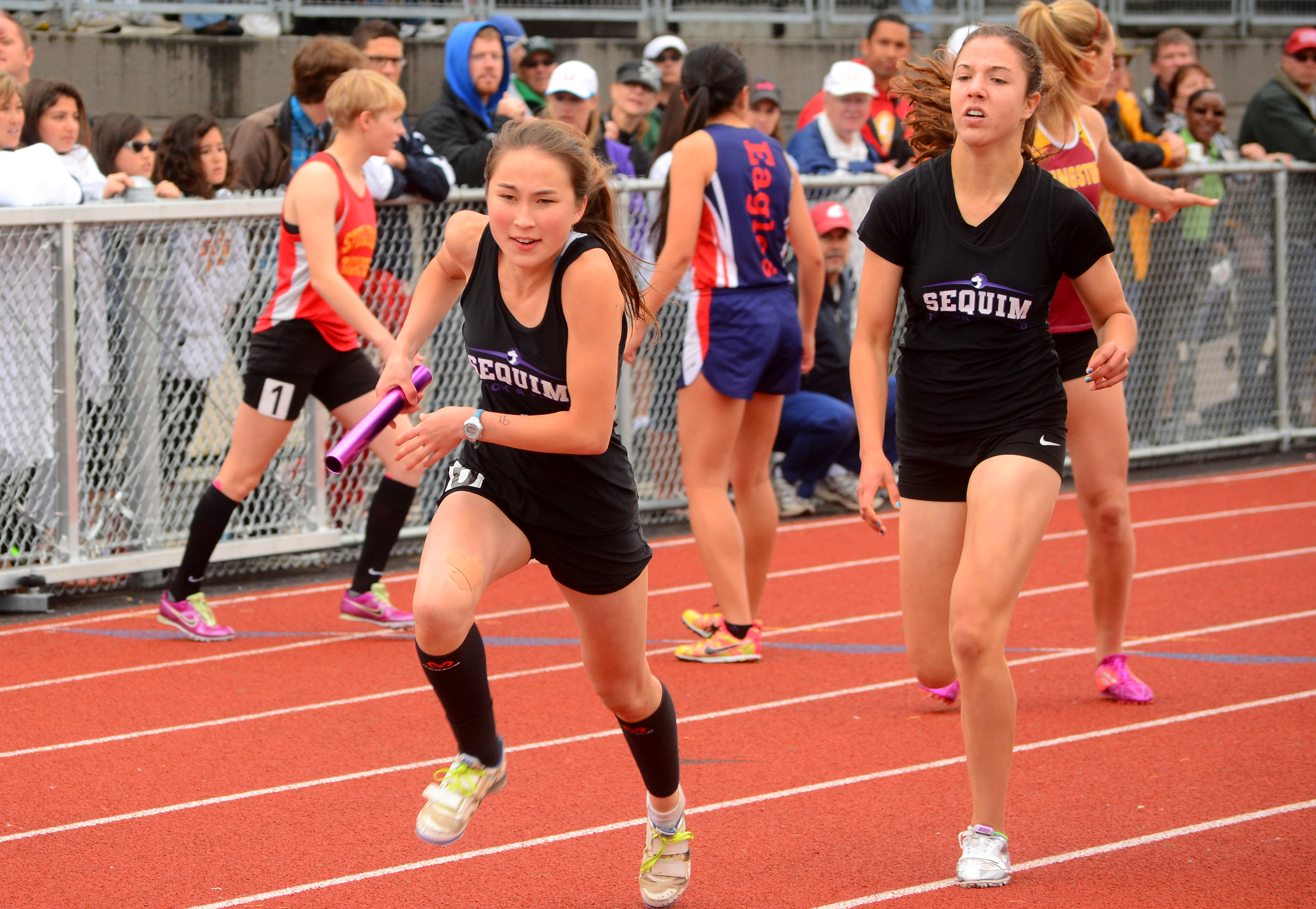 Jasmine McMullin runs with the baton during the 4x400-meter relay at the tri-district championship meet in May. The 4x400 relay was one of three events that McMullin