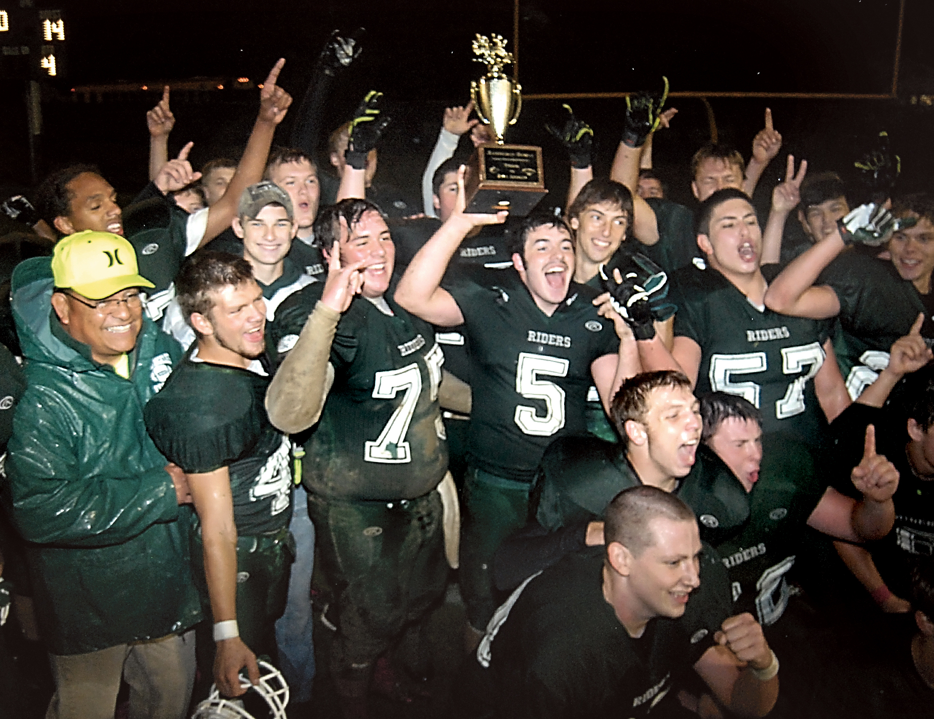 Port Angeles running back Nathan Angevine (5) holds the Rainshadow Rumble trophy while surrounded by his teammates