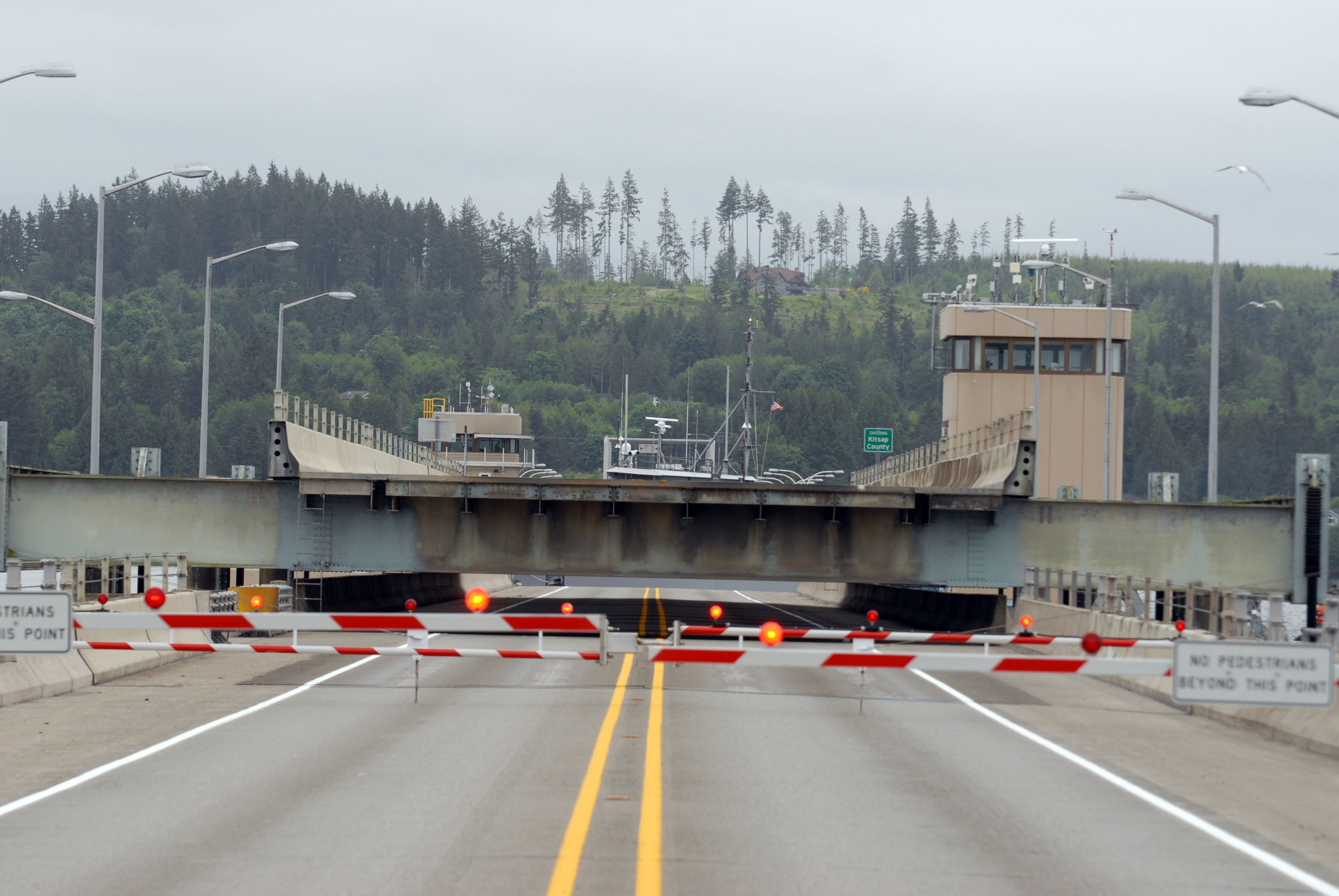 The Hood Canal Bridge is shown in an open position behind traffic barriers. Washington Department of Transportation