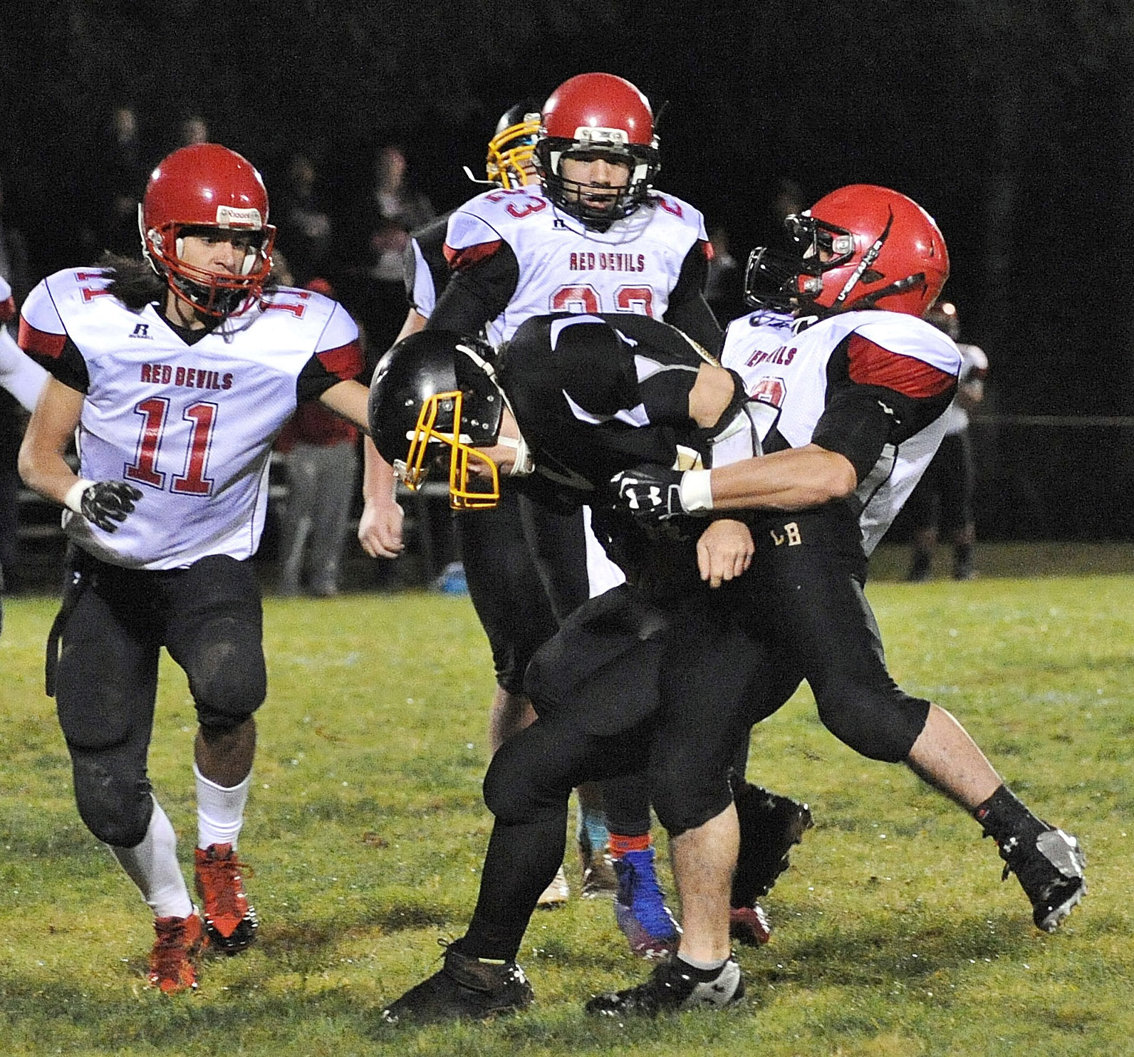 Neah Bay's Elisha Winck (28) hauls down Clallam Bay quarterback Casey Randall. Also in pursuit for Neah Bay are Josh Monette (11) and Chris Martinez (23). Lonnie Archibald/for Peninsula Daily News