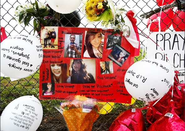 A poster made with photos of the six Marysville High School kids involved in the Oct. 24 shooting hangs with other memorials on the fence at the edge of the schoolgrounds. The (Everett) Herald