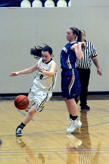 Forks' Skyler DeMatties (left) drives around Rochester's Alexis Seymour during the Spartans' 52-32 loss to the Warriors. Lonnie Archibald/for Peninsula Daily News
