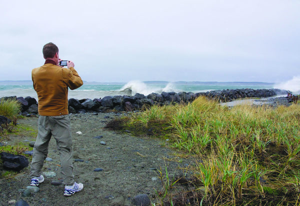 Nik Lance of Port Townsend records some big wave action at Point Wilson on Monday with his cellphone camera. Steve Mullensky/for Peninsula Daily News