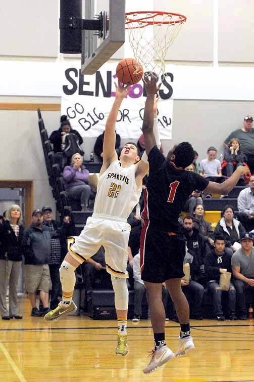 Forks' Parker Browning shoots while defended by Neah Bay's Rwehabura Munyagi Jr. Lonnie Archibald/for Peninsula Daily News