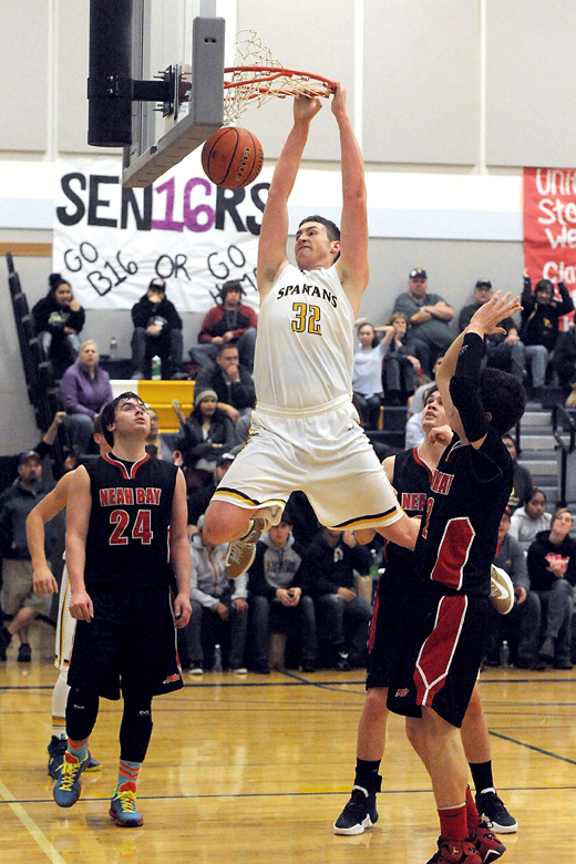 Forks' Marky Adams (32) dunks while Neah Bay's Ryan Moss (24)