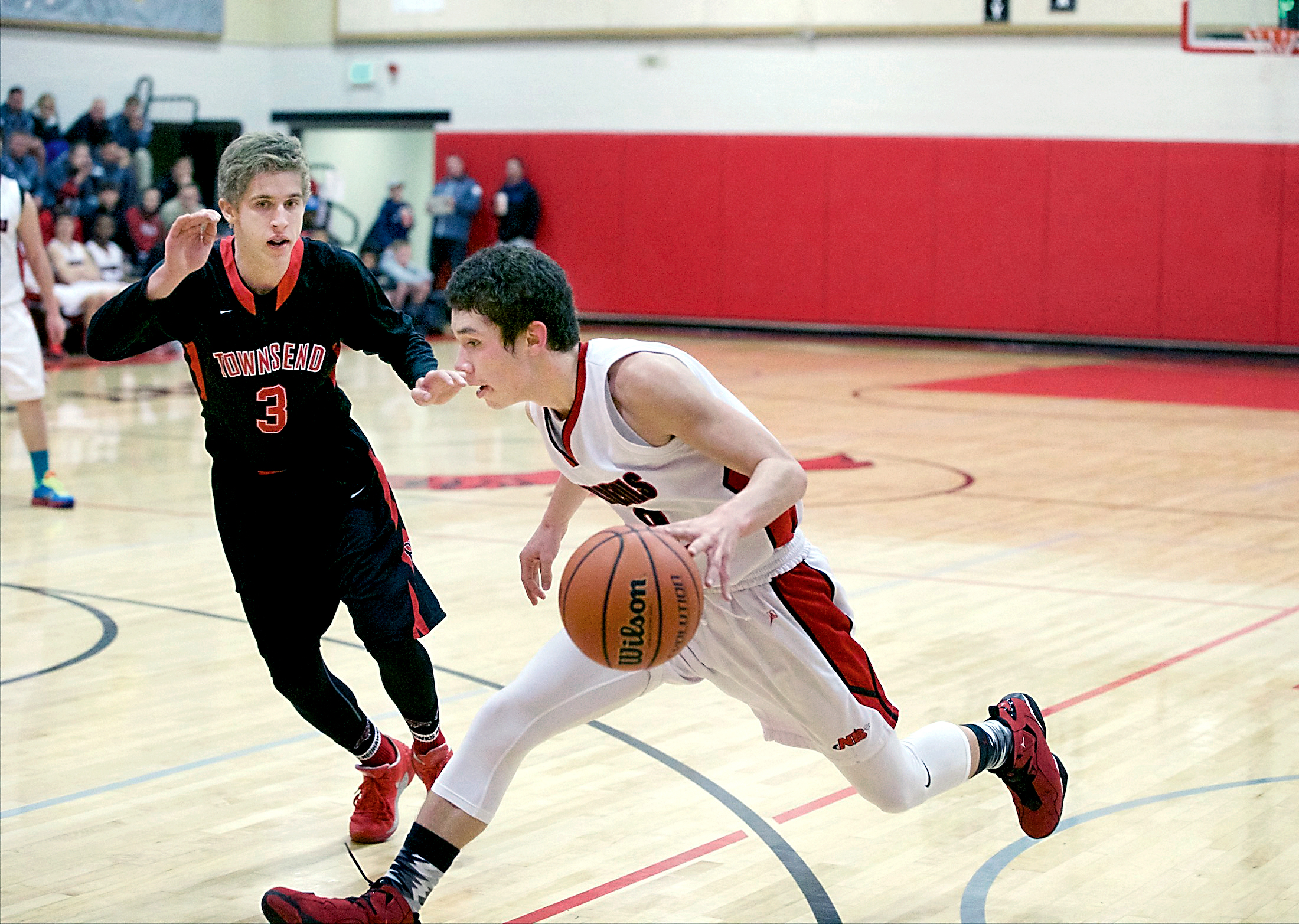 Neah Bay's Jericho McGimpsey drives against Port Townsend's Jacob Ralls (3) during a Crush in the Slush tournament game in Port Townsend. The Red Devils rallied from early deficits to win twice at the tournament. Steve Mullensky/for Peninsula Daily News