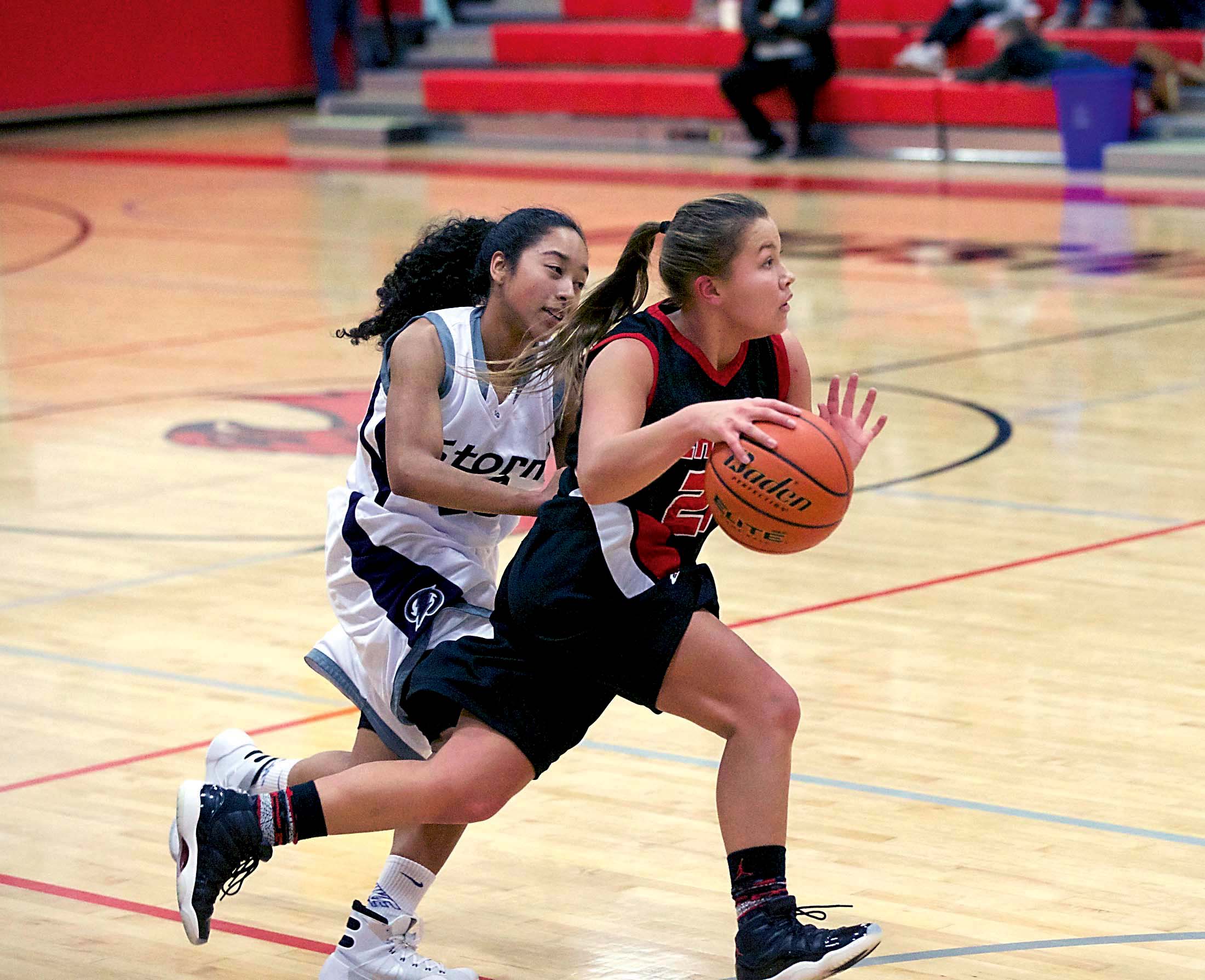 Neah Bay's Gina McCalley drives past Squalicum's Desiree Henry in Port Townsend on Tuesday. Steve Mullensky/for Peninsula Daily News