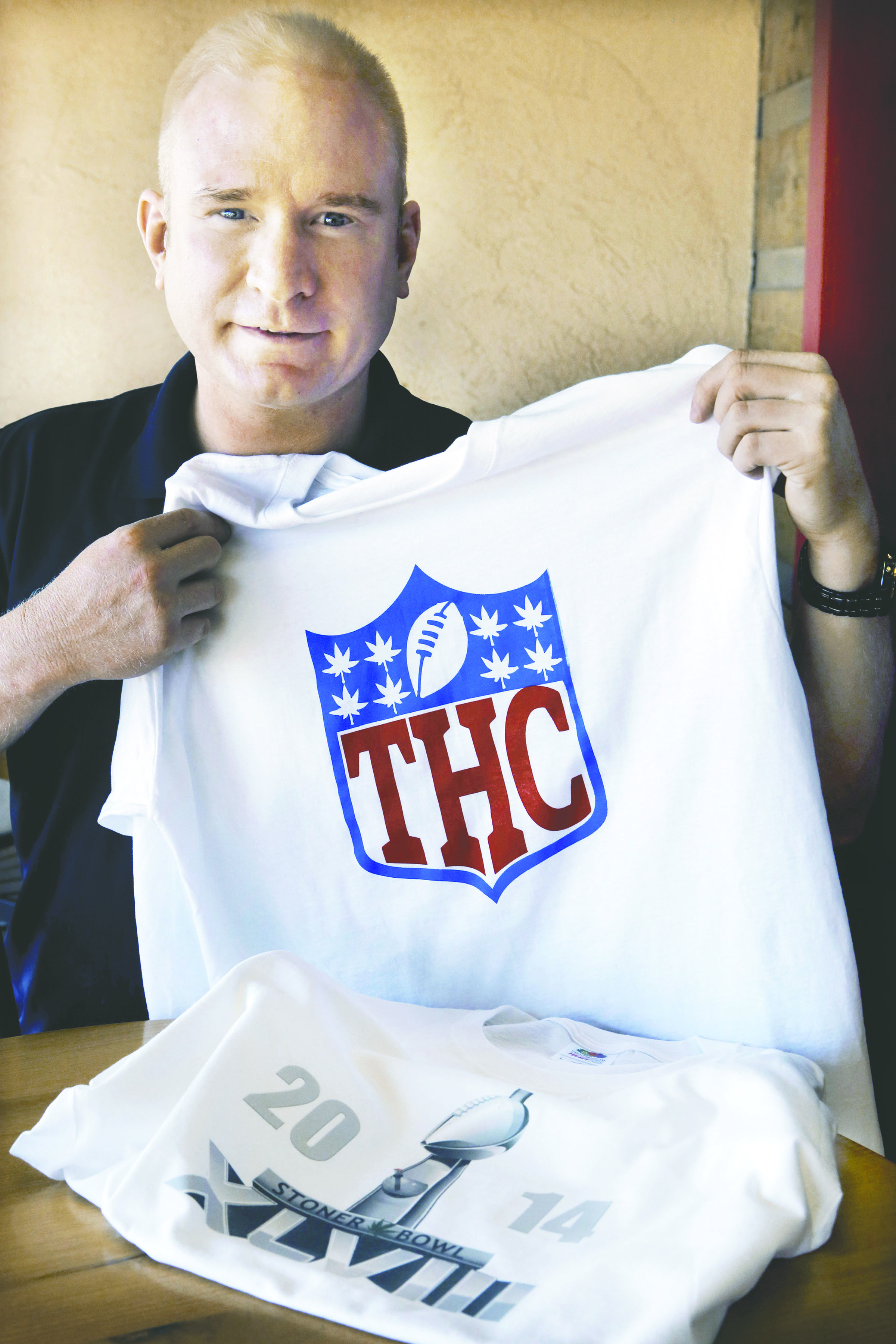 Bryan Weinman is pictured with one of his “Stoner Bowl” T-shirts in Denver. The Associated Press