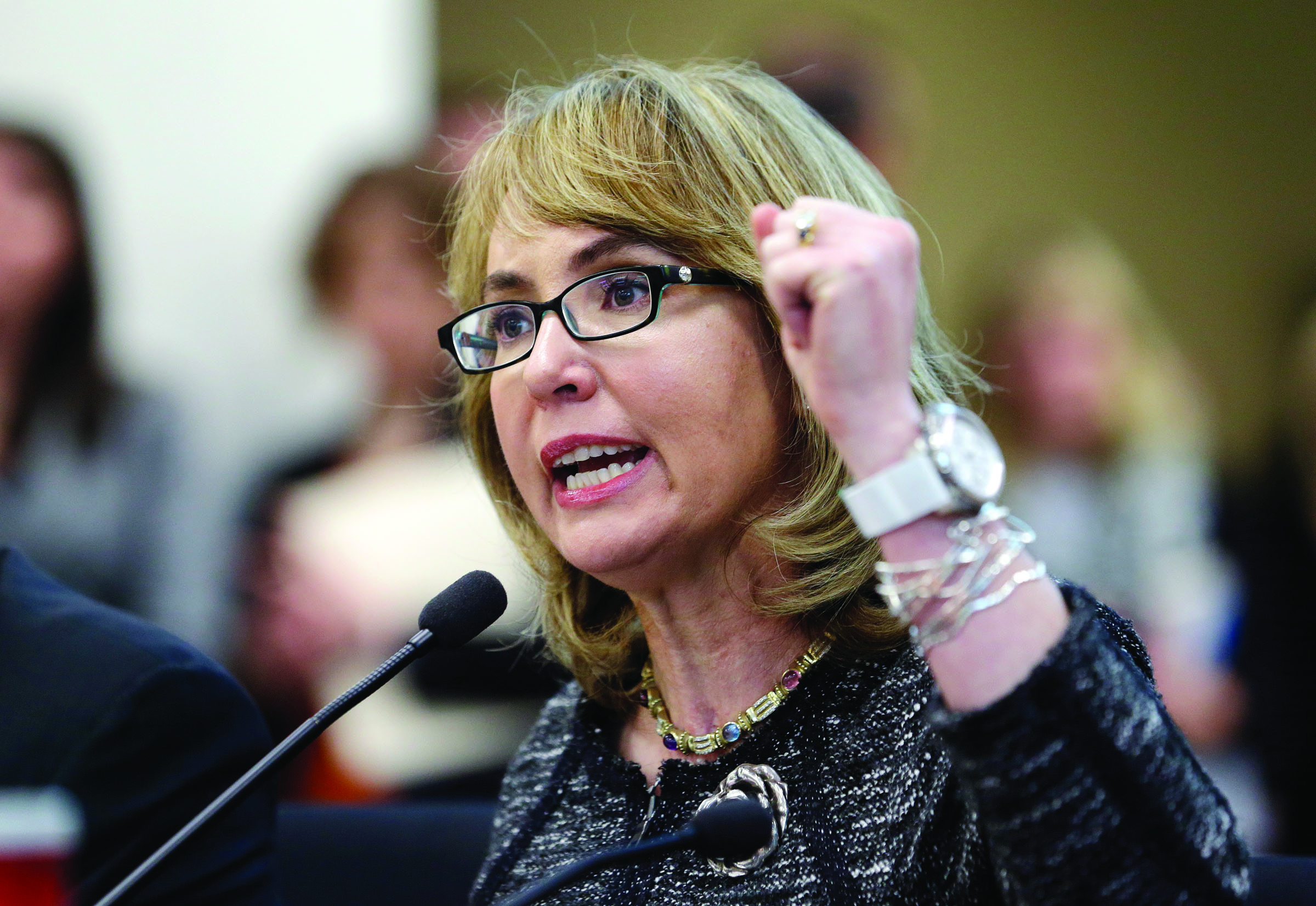 Former Arizona Congresswoman Gabrielle Giffords pumps her fist as she testifies before a Washington state House panel Tuesday in Olympia. — The Associated Press
