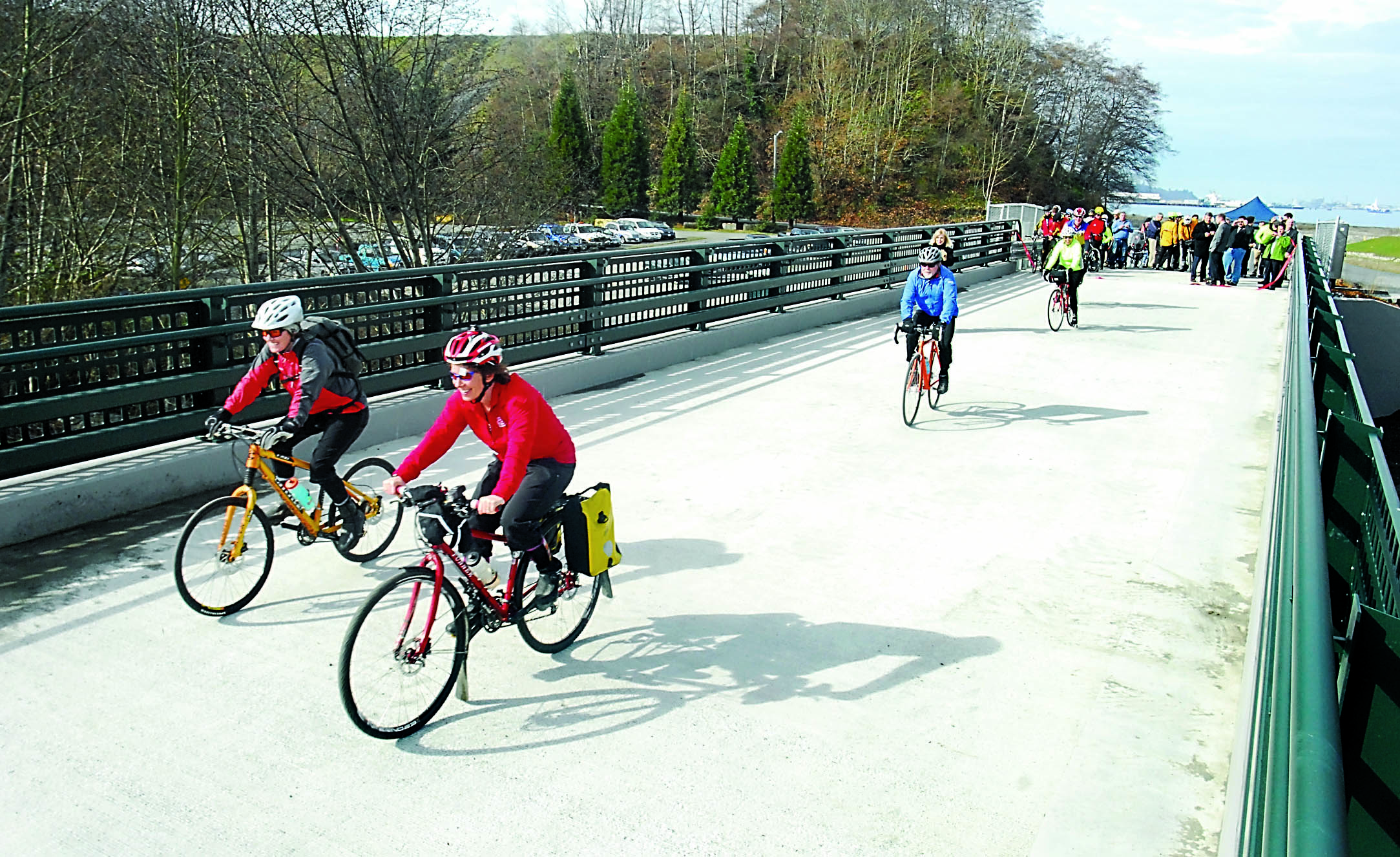 The first bicyclists make their way across a new bridge crossing Ennis Creek at the former Rayonier mill site in Port Angeles after the bridge was formally opened Thursday. — Keith Thorpe/Peninsula Daily News