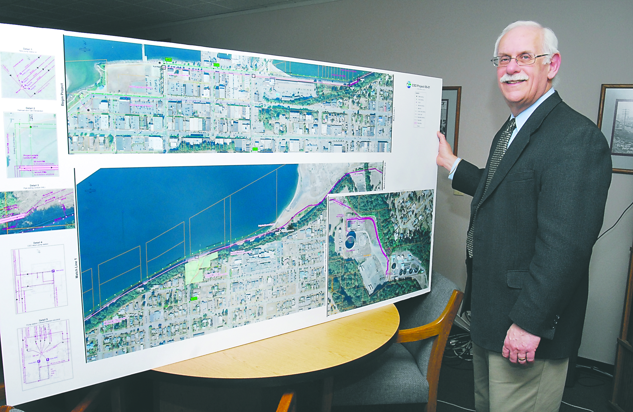 Public Works and Utilities Director Glenn Cutler stands with a display at City Hall showing an aerial schematic diagram of the citys combined sewer outflow project