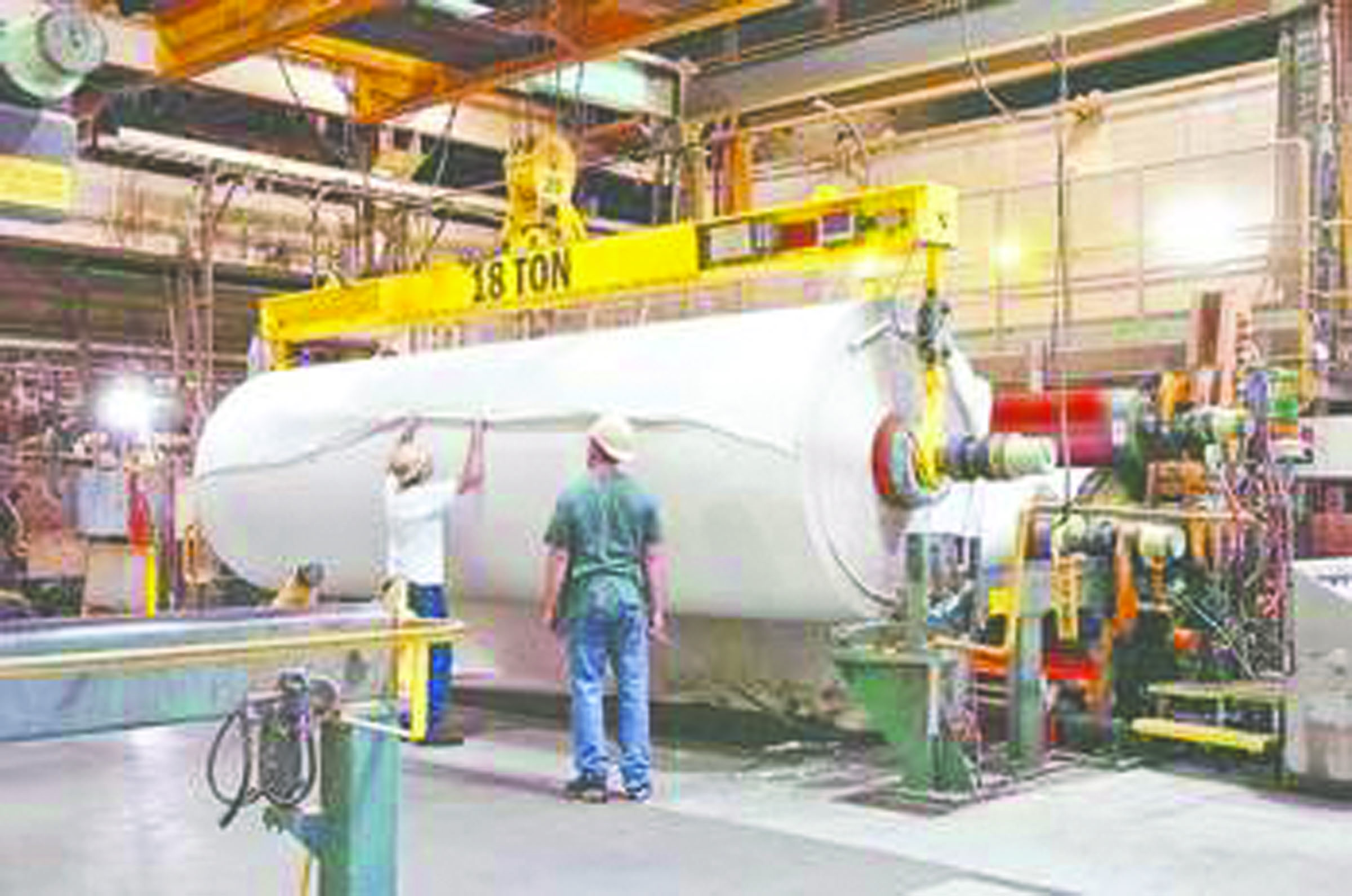 Nippon Paper Industries USA millworkers work with a jumbo roll of paper in this 2010 photo.  -- Peninsula Daily News archives