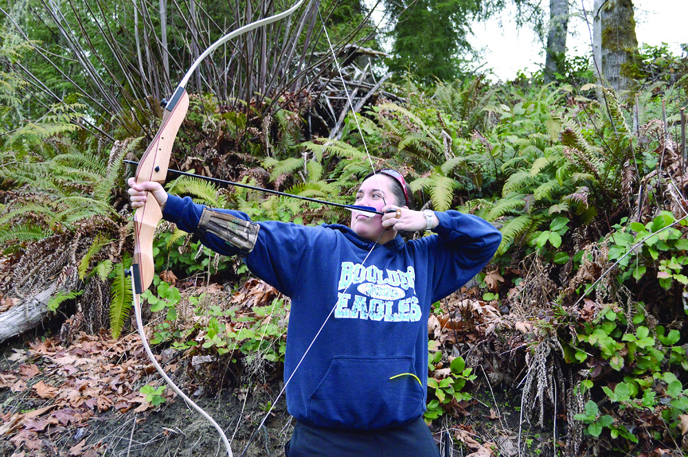 Brittainy Girr pulls back the bow for a shot on the Wapiti Bowmen's archery course. Joe Smillie/Peninsula Daily News