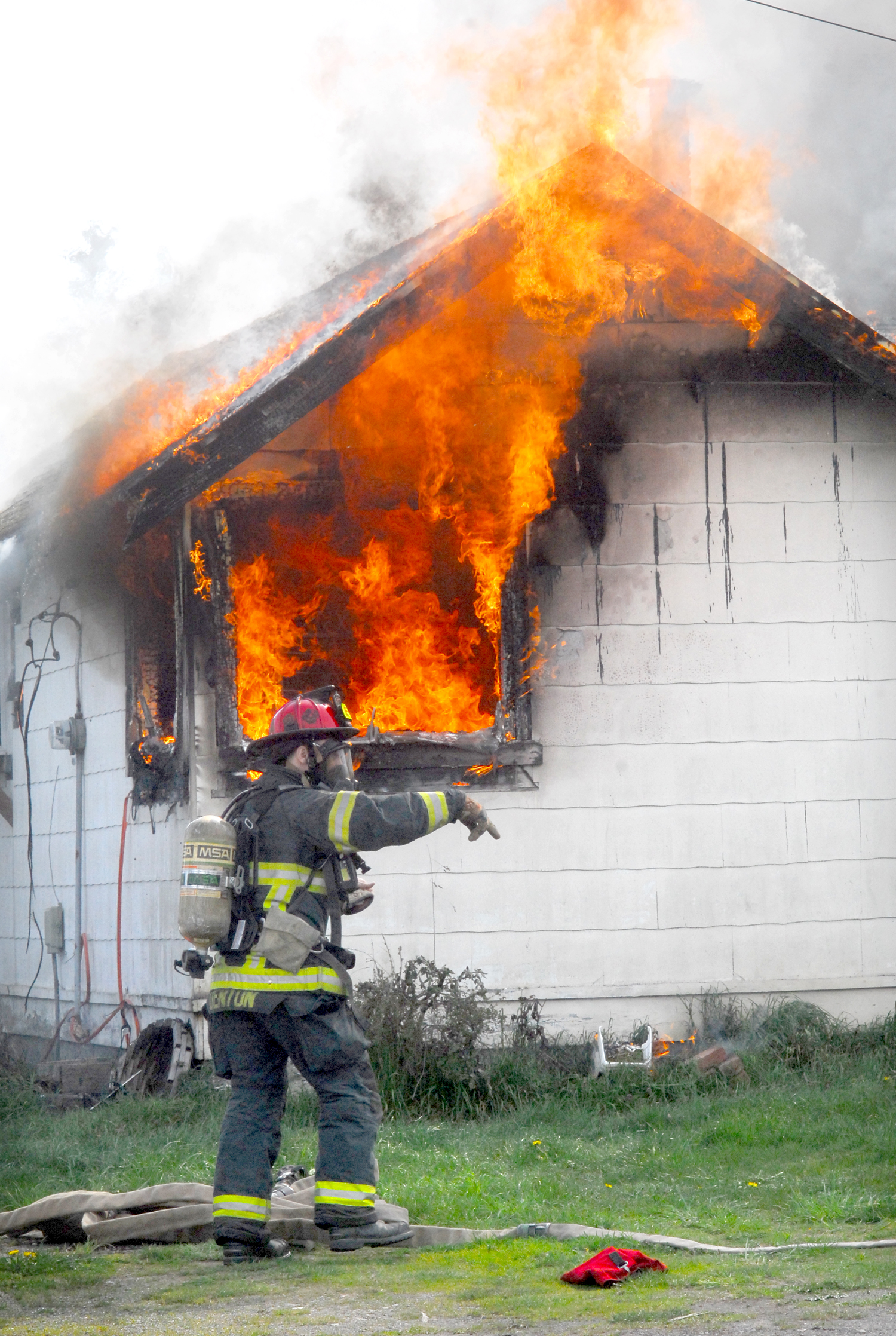 Port Angeles firefighter Kevin Denton prepares to take on a fire that destroyed a house at 4017 W. Fairmount Ave. in Port Angeles today. Photo by Keith Thorpe/Peninsula Daily News