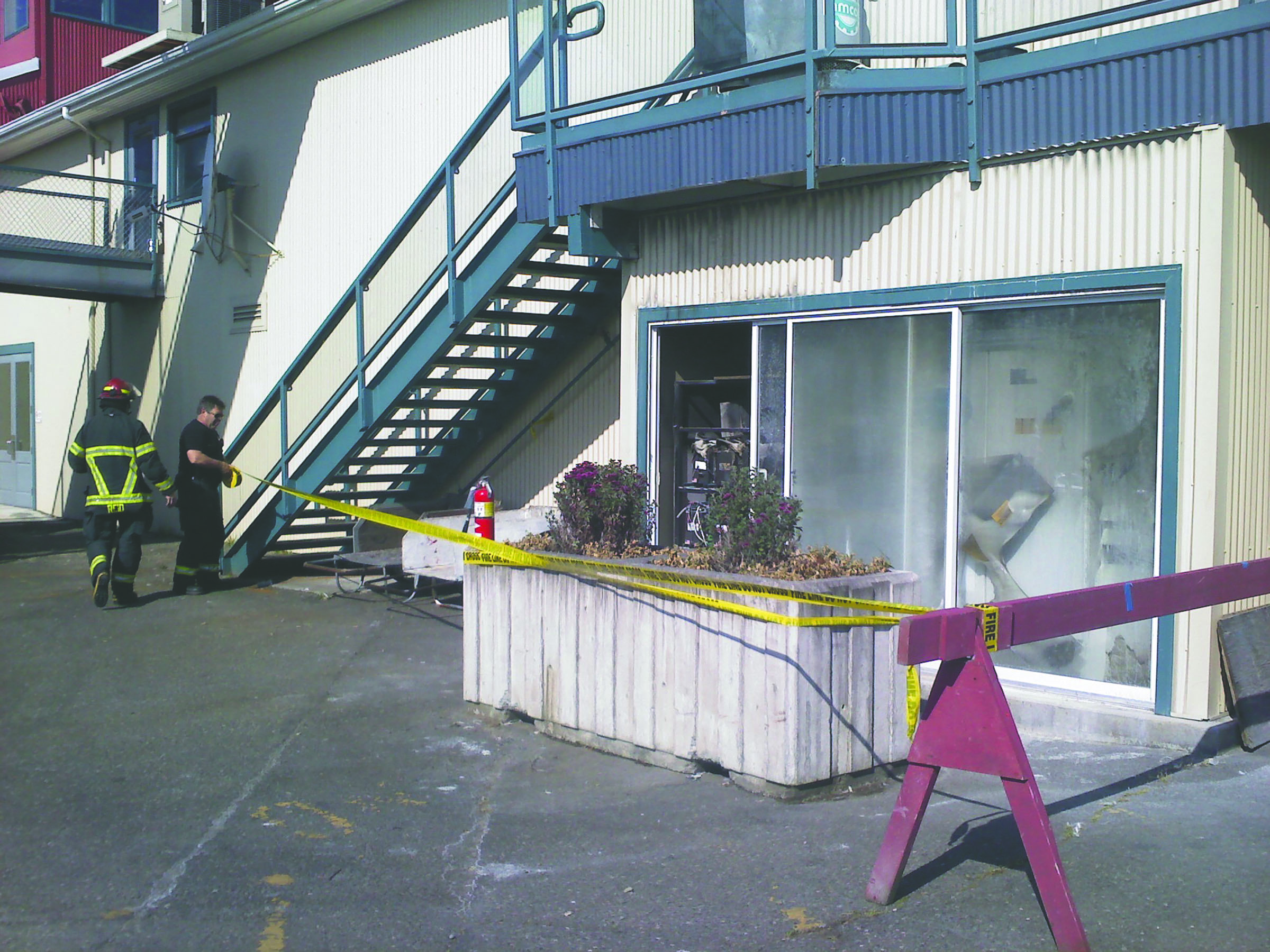 Firefighters tape off an area around the battery room where a small fire broke out this morning at The Landing mall in Port Angeles.  -- Photo by Arwyn Rice/Peninsula Daily News