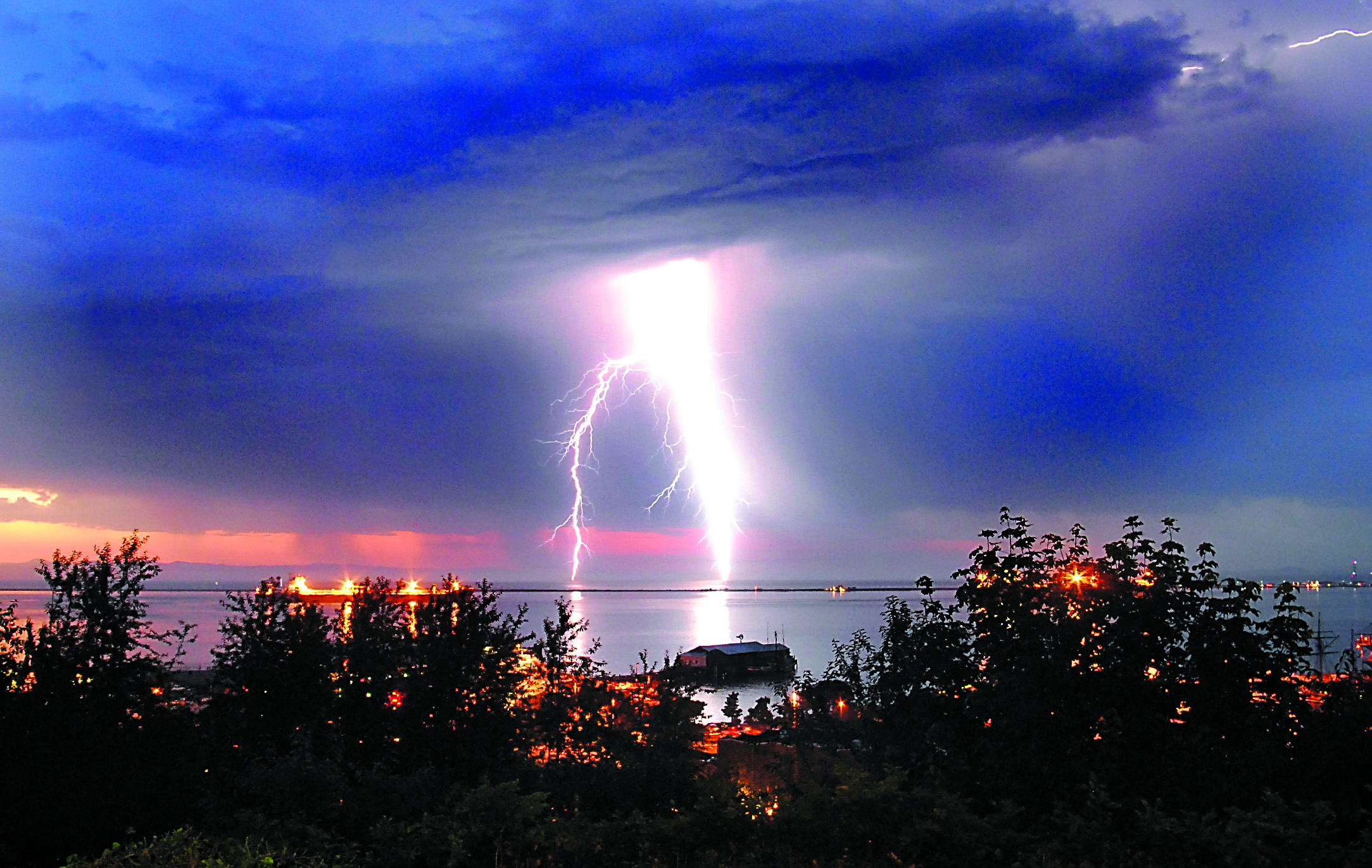 This unusually fat lightning bolt over the Strait of Juan de Fuca was taken from Port Angeles on Friday evening. Port Angeles Harbor and Ediz Hook are visible in the foreground.  -- Photo by Keith Thorpe/Peninsula Daily News