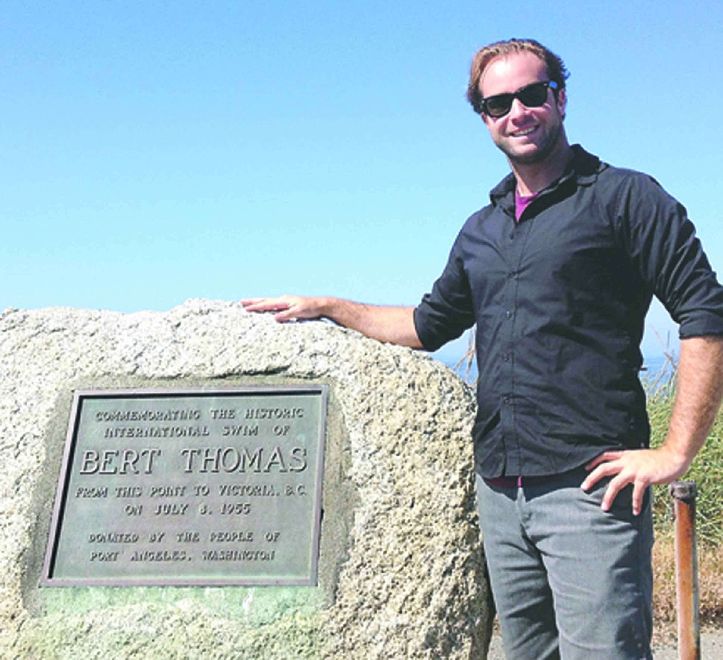 Distance swimmer Andrew Malinak stands with the Ediz Hook monument that commemorates the first modern swim to Port Angeles across the Strait of Juan de Fuca by Bert Thomas in 1955. Thomas died in 1972 (see accompanying story on homepage).
