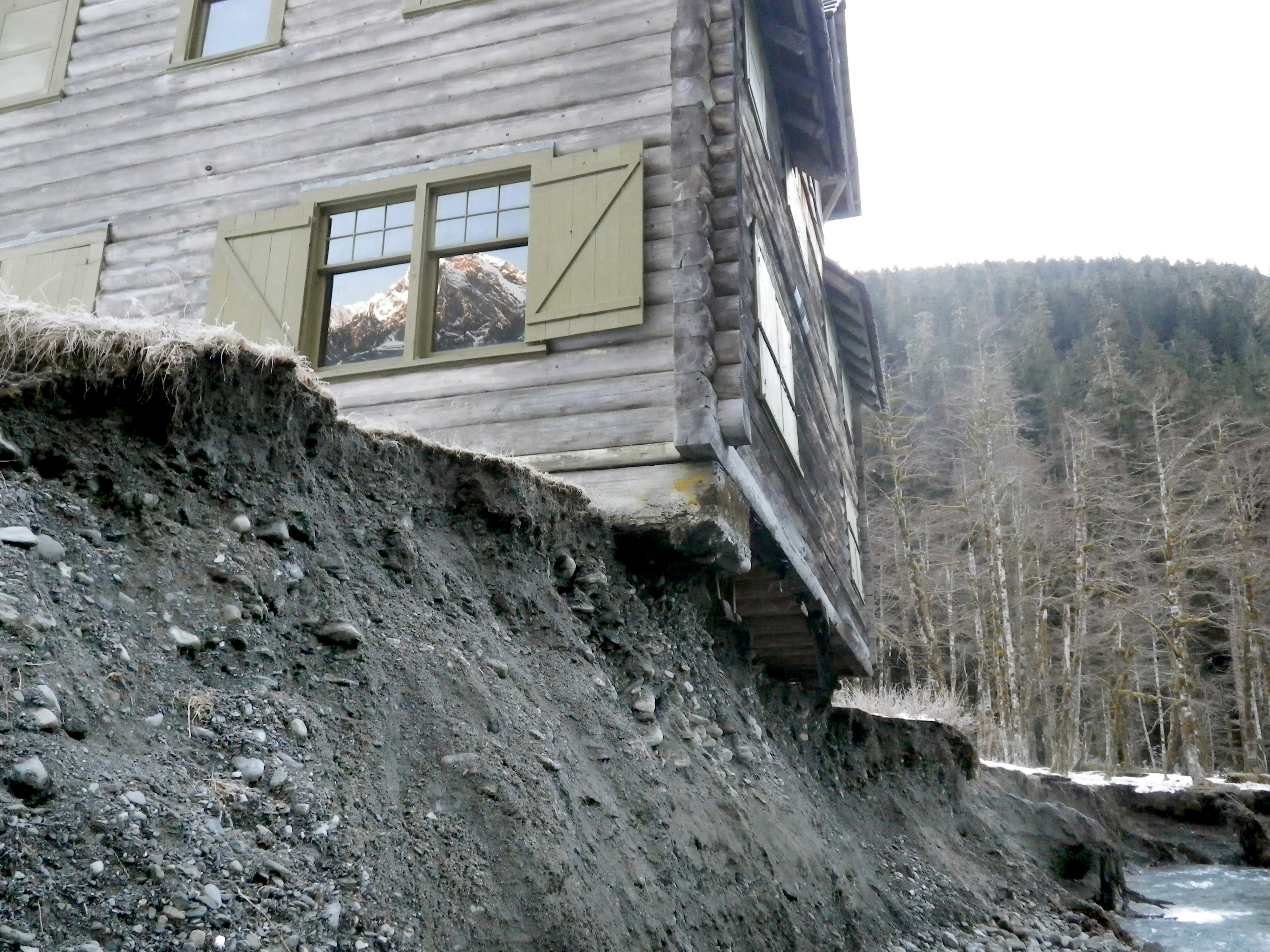 The Enchanted Valley Chalet is shown precariously over the bank of the changing East Fork Quinault River last March.  —National Park Service photo