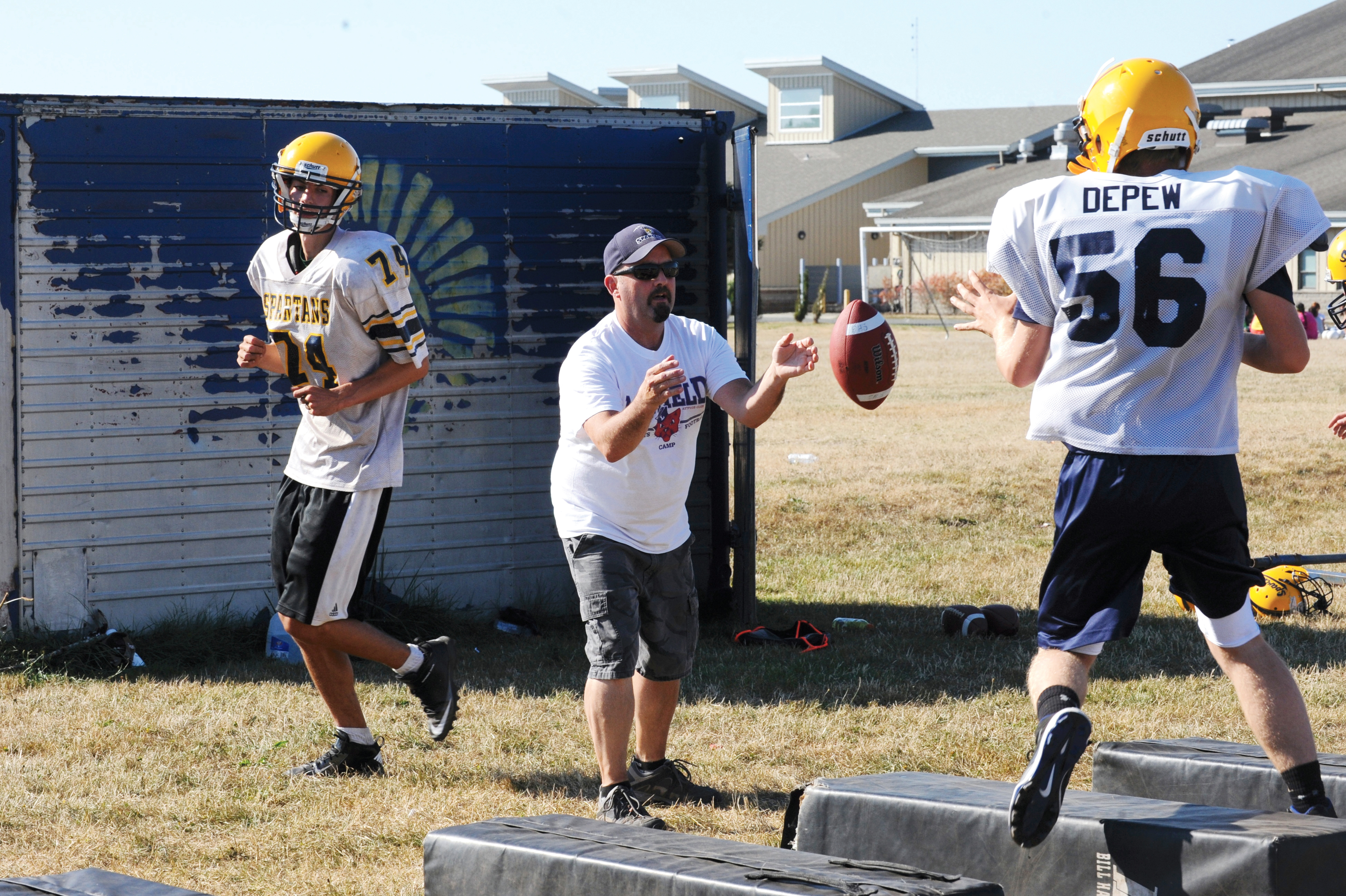 Forks head coach Mark Feasel pitches the ball to freshman Reece DePew during a drill at practice at Forks High School last week. Lonnie Archibald/for Peninsula Daily News