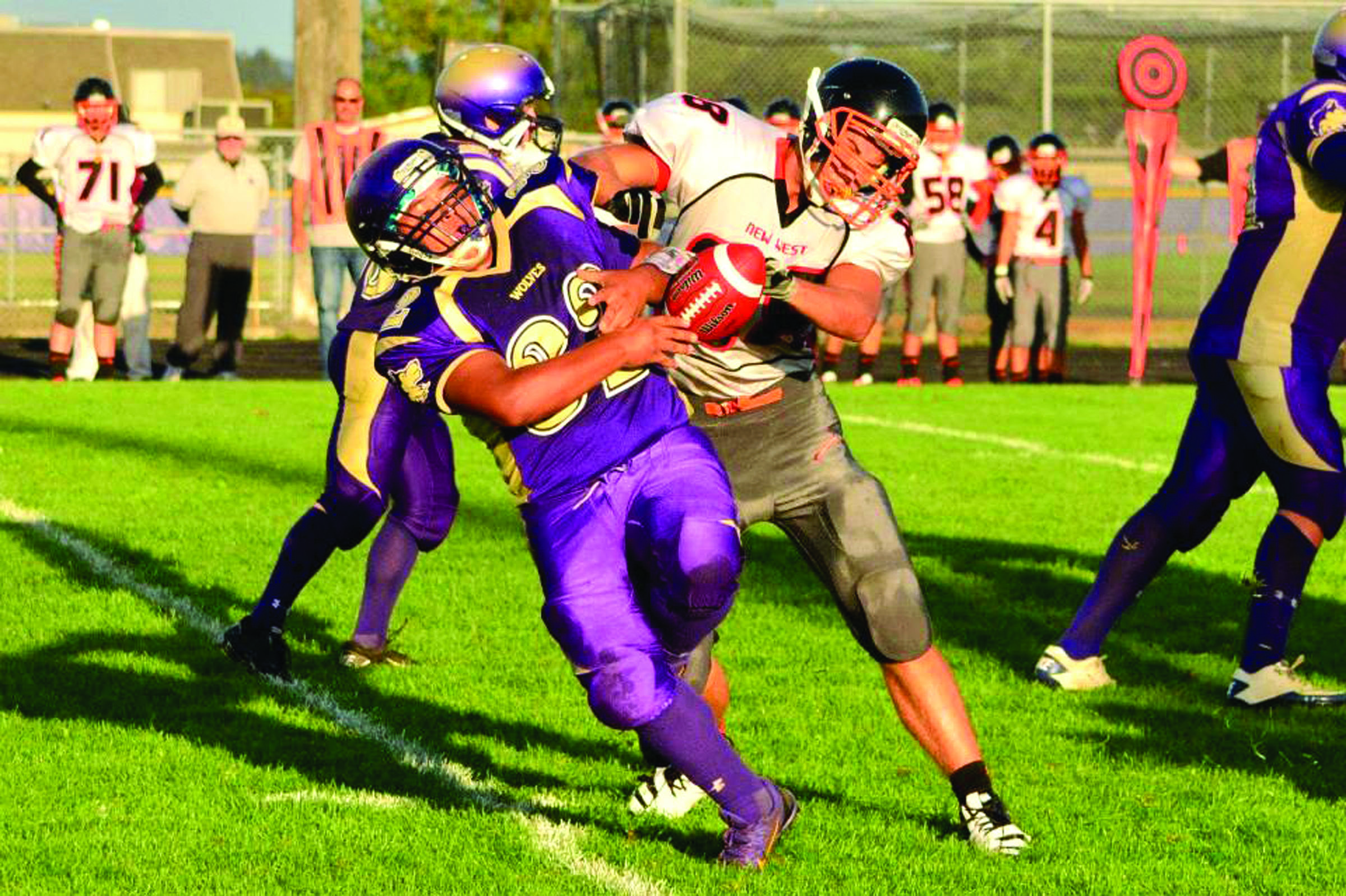 Sequim fullback Arnold Black loses control of the ball after a big hit by New Westminster linebacker Bogdan Pavel. Tim Wright/for Peninsula Daily News