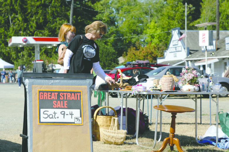 Visitors look over the goods on display at the community sale in Joyce during the 2013 Great Strait Sale. Juan de Fuca Scenic Byway Association