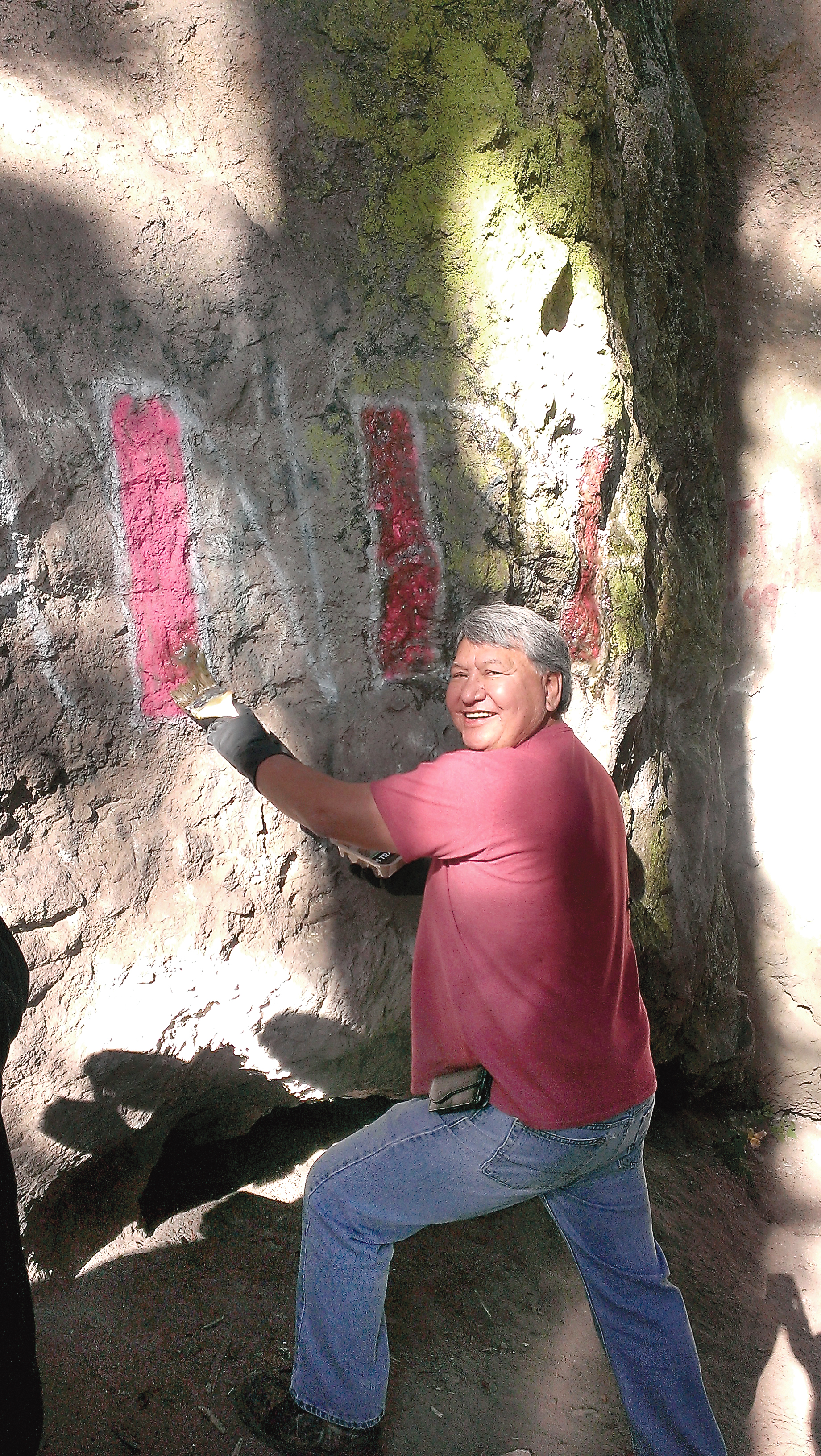 Steve Johnson scrubs a graffito from Tamanowas Rock during a seven-hour cleanup session Sept. 11. Bill Laubner