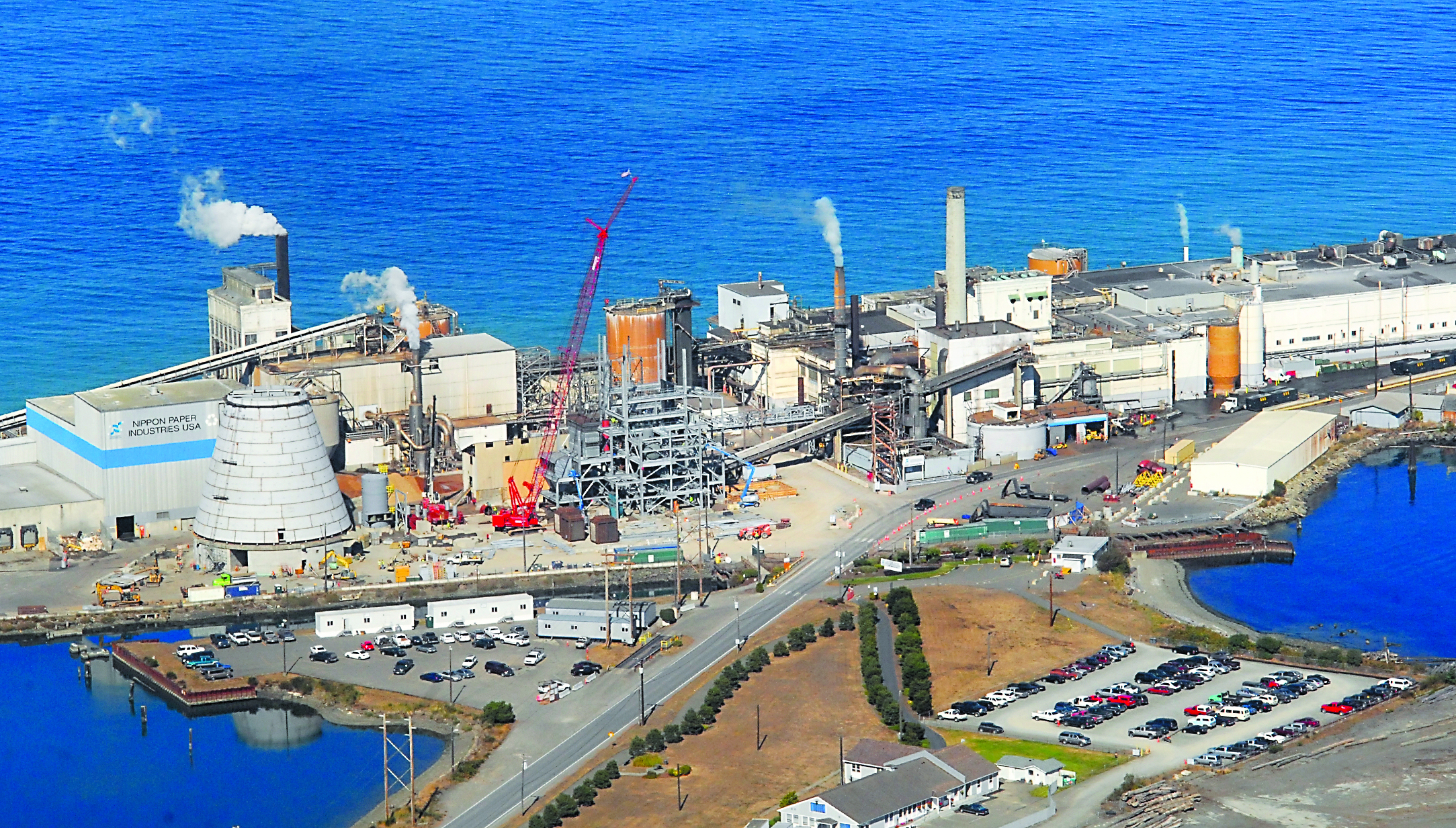 A biomass-fueled cogeneration plant takes shape at the Nippon Paper Industries USA mill at the base of Ediz Hook in Port Angeles. The cone-shaped building at the left is the fuel storage facility. To the right of that building are the first four stories of the steel skeleton that will be the 110-foot boiler.  -- Photo by Keith Thorpe/Peninsula Daily News