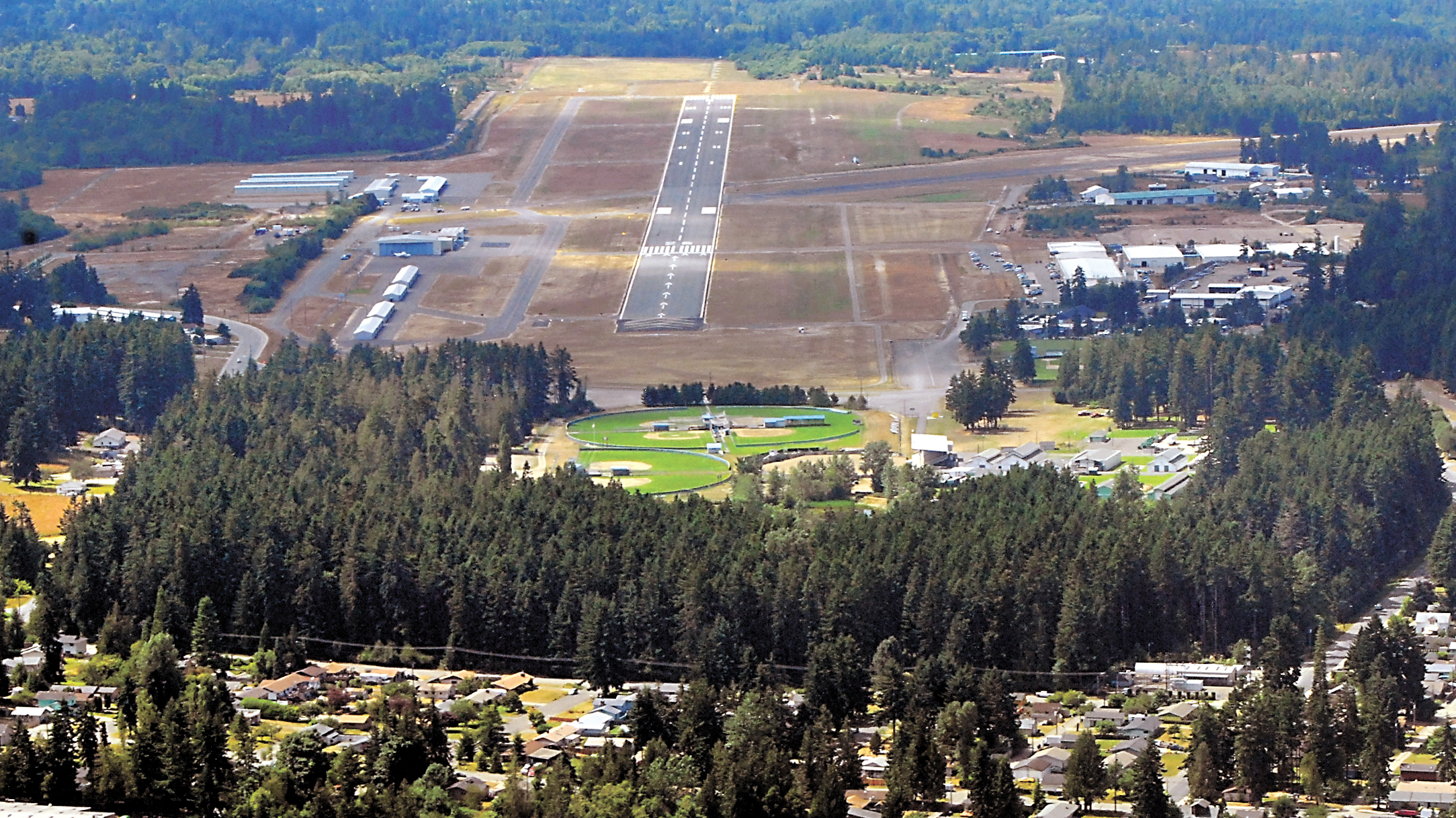 Trees in Lincoln Park in Port Angeles stand in the approach to Runway 26 at William R. Fairchild International Airport on July 29