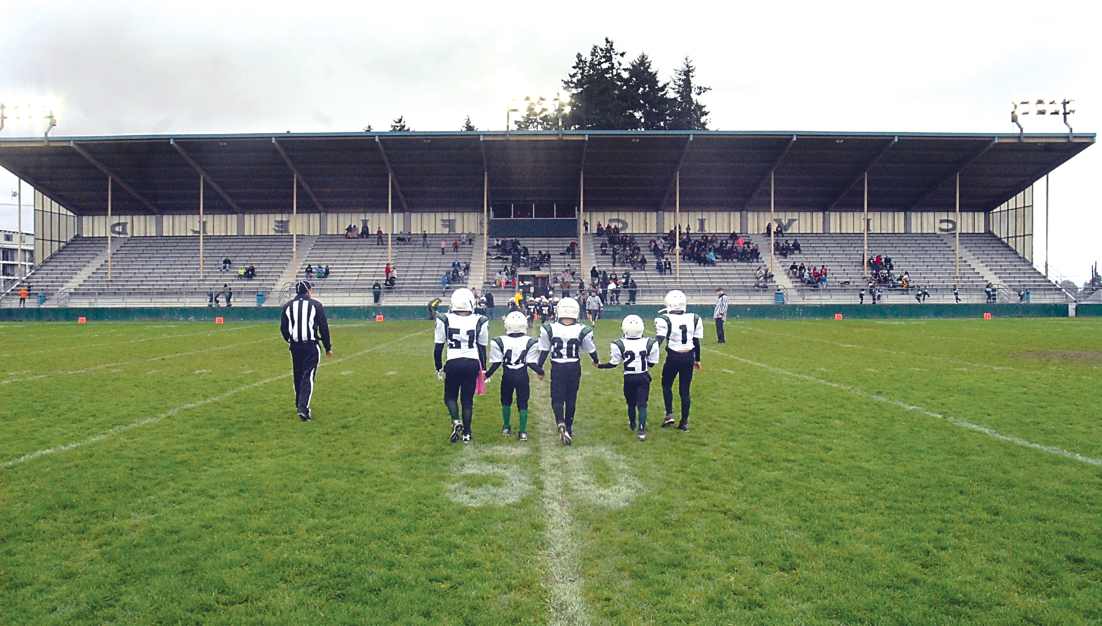 Youth football players walk to midfield for the coin toss at Port Angeles Civic Field on Saturday. —Photo by Keith Thorpe/Peninsula Daily News