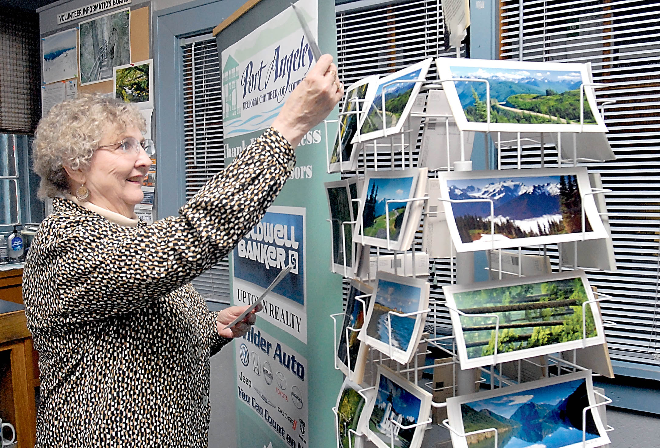 Volunteer Jo-Anne Larson of Port Angeles restocks postcards at the Port Angeles Regional Chamber of Commerce visitor center on the Port Angeles waterfront. —Photo by Keith Thorpe/Peninsula Daily News