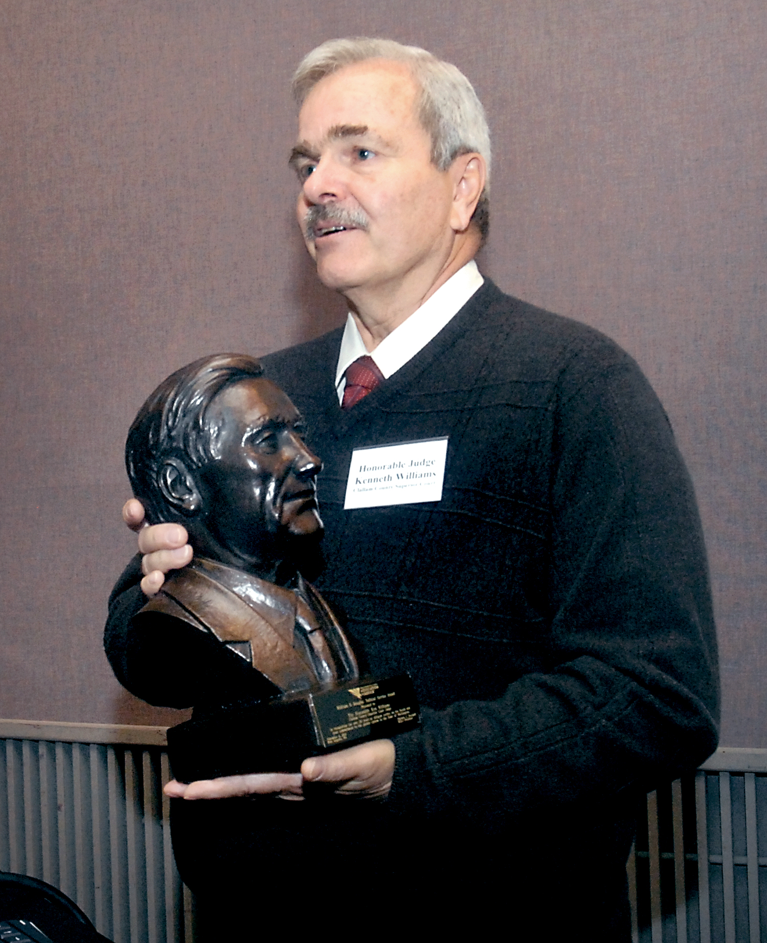 Retired Clallam County Superior Court Judge Ken Williams holds his William O. Douglas Judicial Service Award presented to him Friday in Port Angeles by Deborah Nelson on behalf of the Washington State Association for Justice. Keith Thorpe/Peninsula Daily News