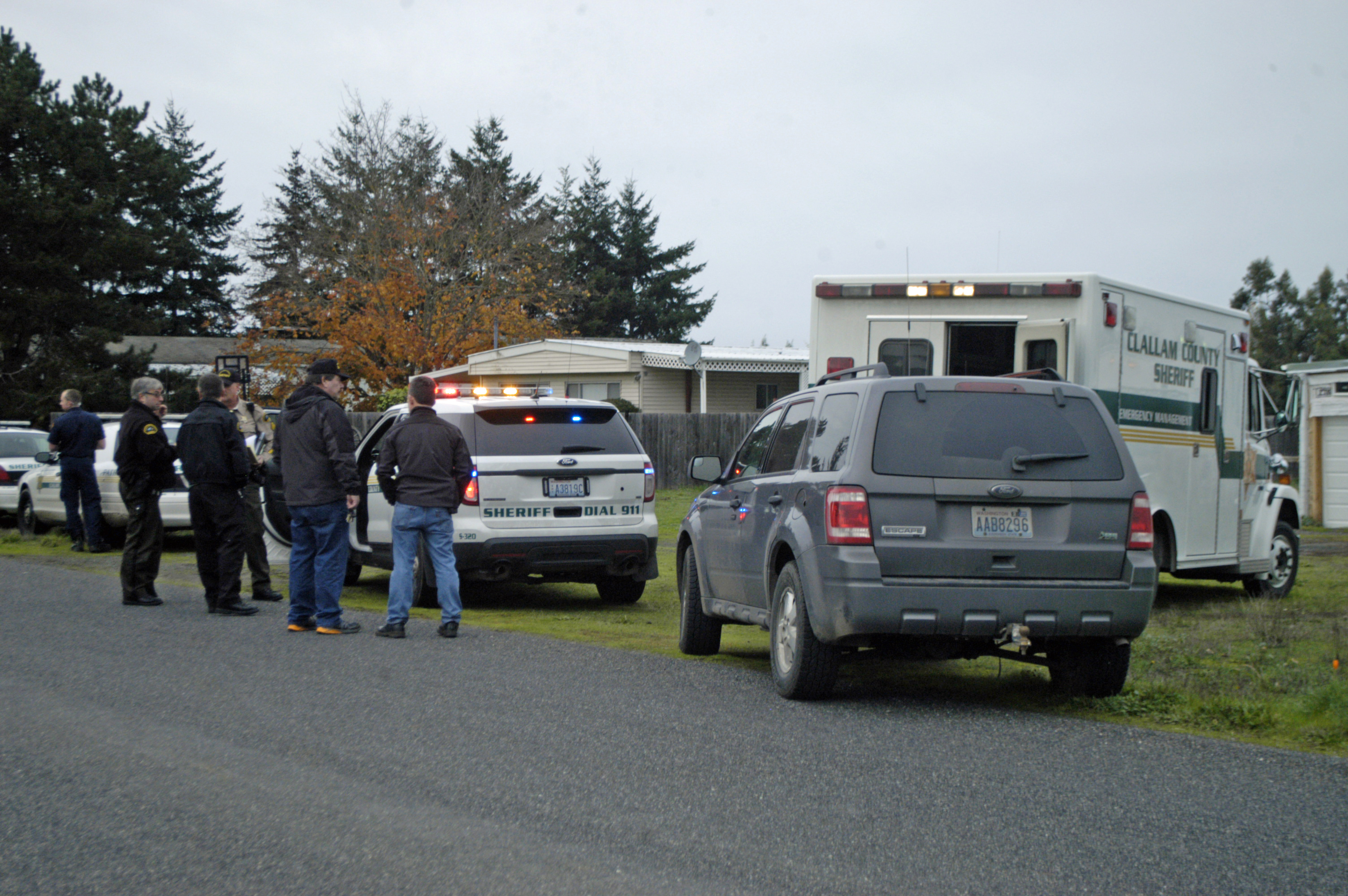 Clallam County Sheriff's deputies gather in front of the residence of Jonathan Sweeney