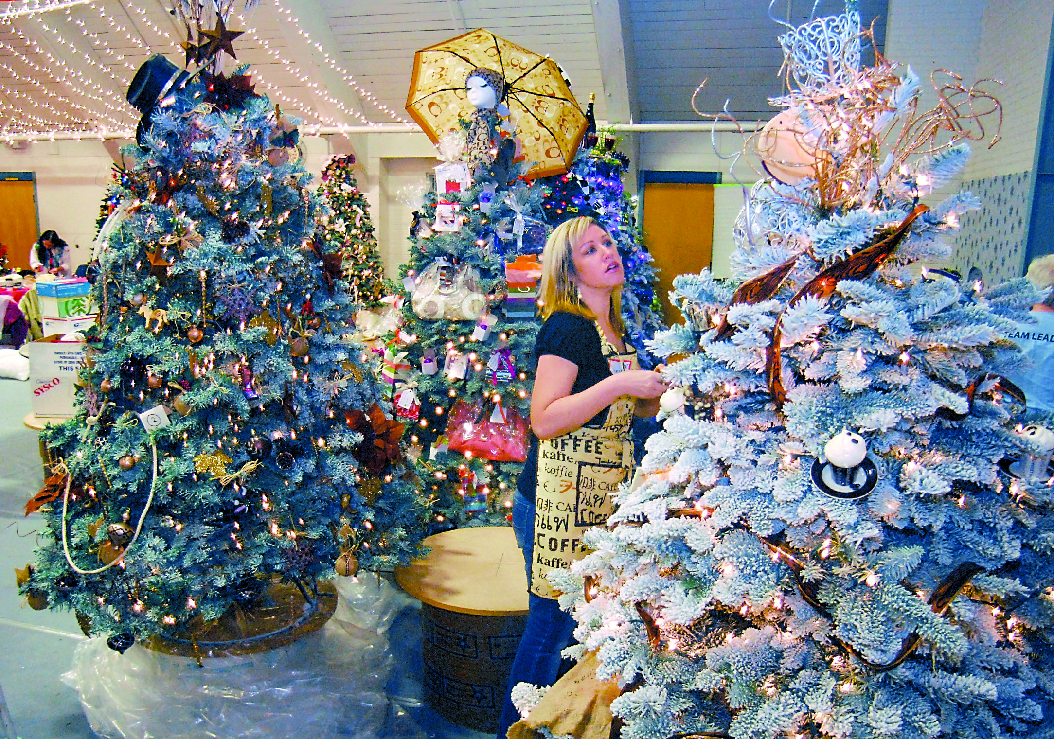 Jamie Scott of Port Angeles decorates a tree titled “Caffeinated Christmas” on Wednesday in preparation for this weekend's Festival of Trees at Vern Burton Community Center in Port Angeles. Keith Thorpe/Peninsula Daily News