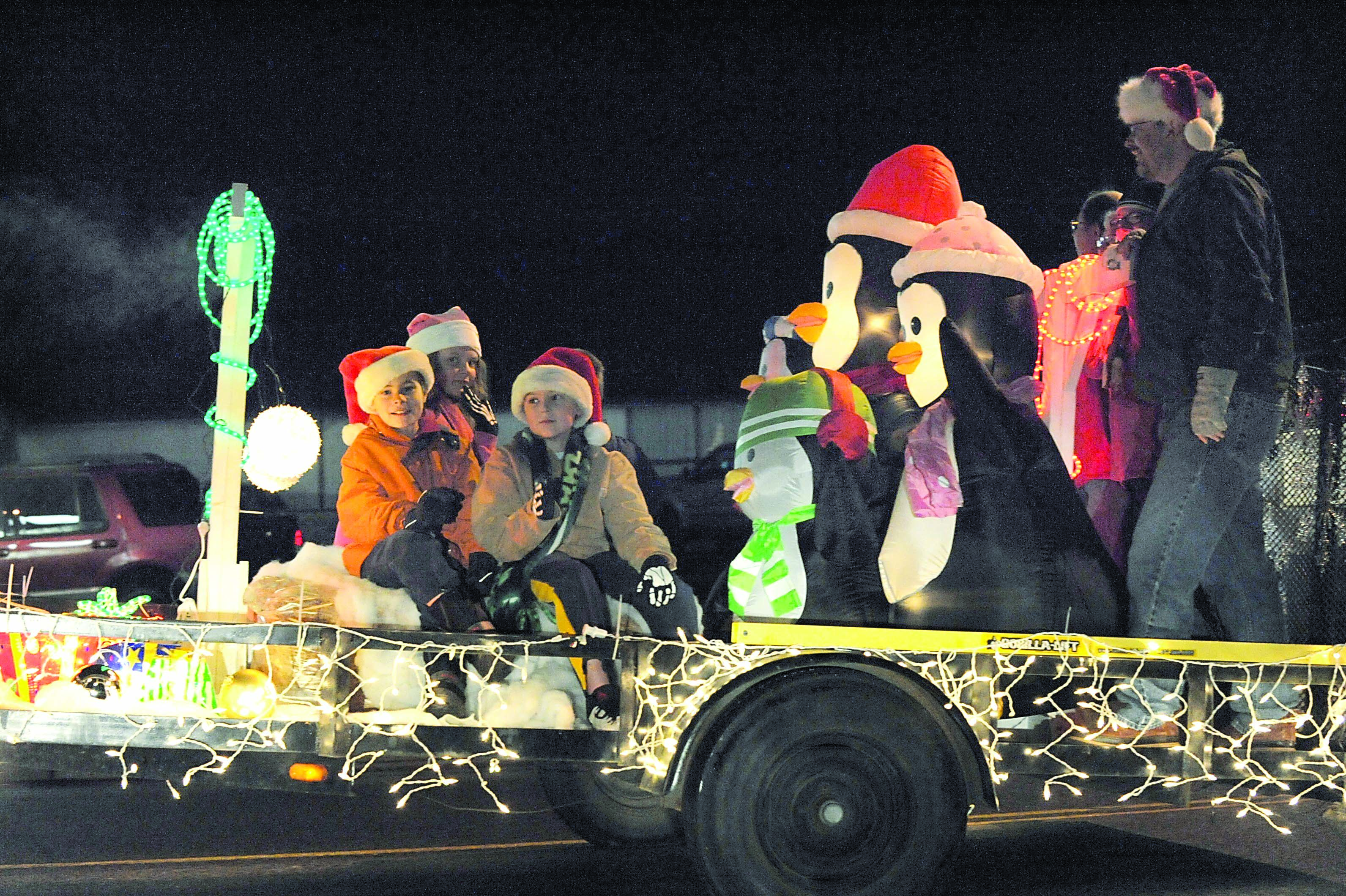 Children and adults ride in a penguin-adorned float entered by the city of Forks in the 2011 Twinkle Light Holiday Parade. Lonnie Archibald/for Peninsula Daily News