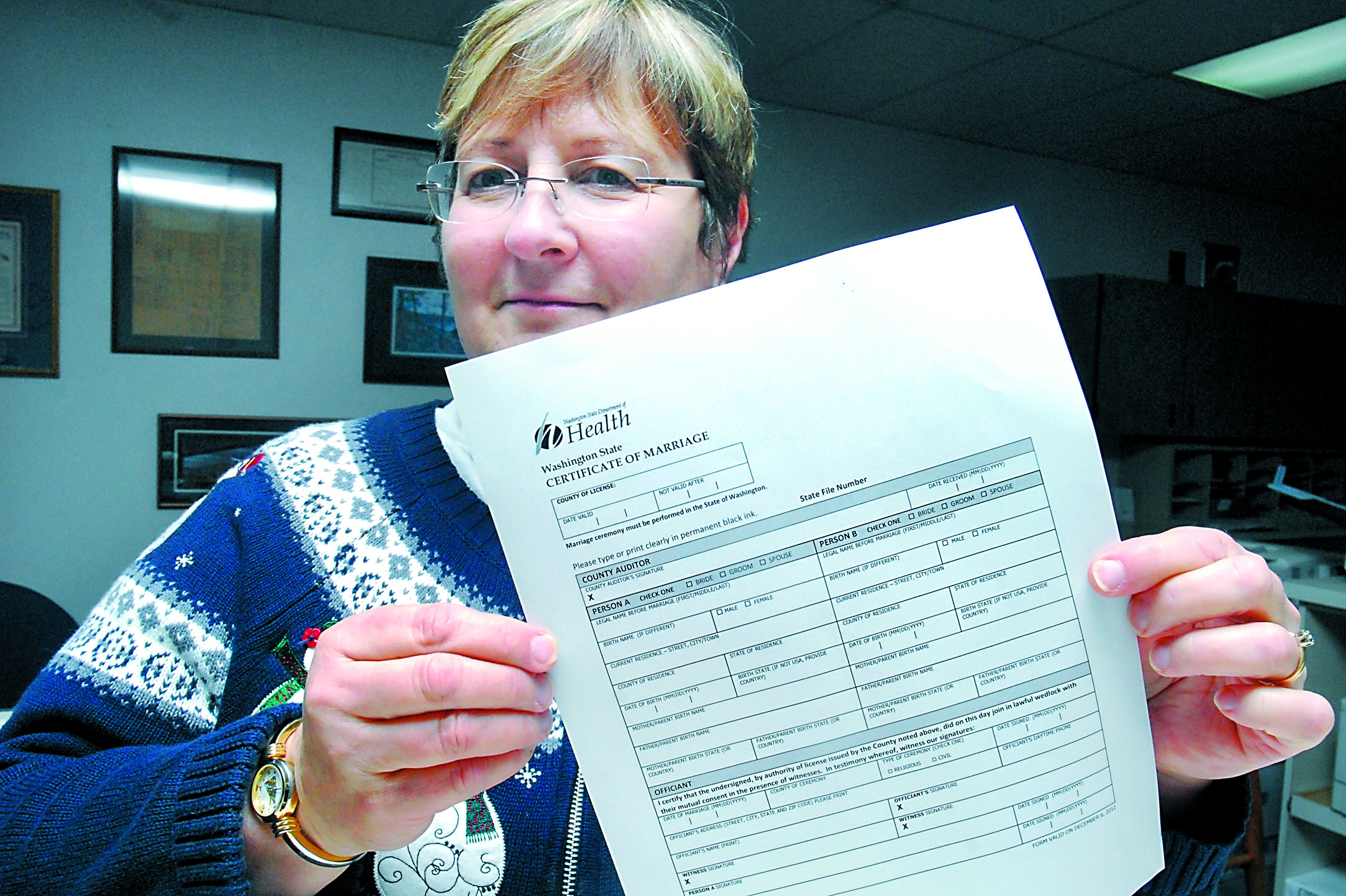 Clallam County Auditor Patty Rosand holds a marriage form that recognizes same-sex marriages by having the applicant designate Person A and Person B.  -- Photo by Keith Thorpe/Peninsula Daily News