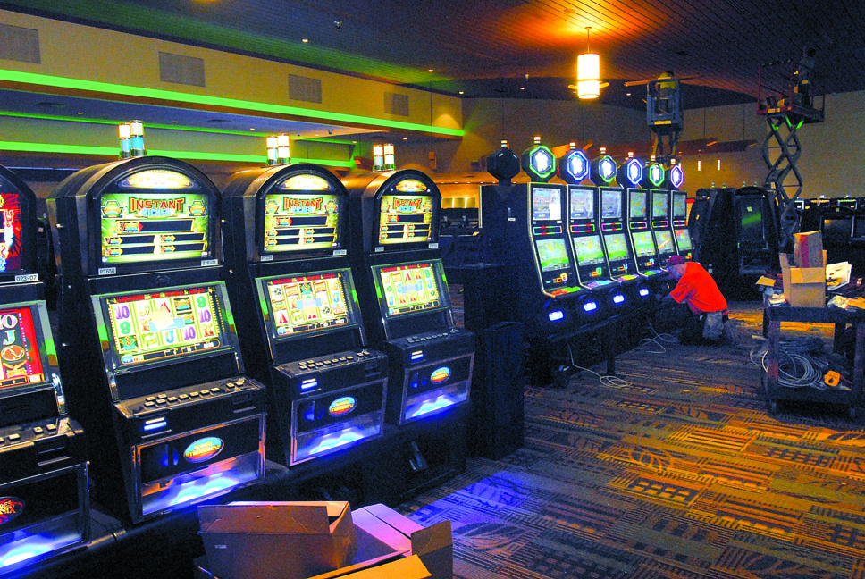 Steve Haase of Las Vegas-based Yesco Sign Co. installs a bank of slot machines on Thursday in preparation for Saturday's grand opening at 7 Cedars Casino in Blyn. Keith Thorpe/Peninsula Daily News