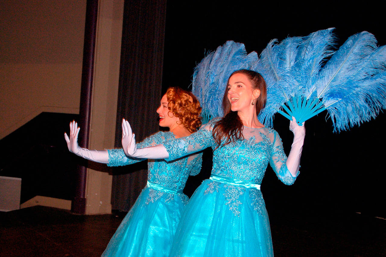 Danielle Lorentzen and Kate Long, cast as sisters in “Irving Berlin’s White Christmas,” flash feathered fans as they sing and dance on stage at Sequim High School Theater. (Erin Hawkins/Olympic Peninsula News Group)