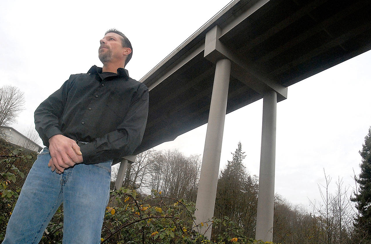Richard Wishart of Port Angeles stands near the spot where his daughter, 15-year-old Ashley Wishart, leapt to her death from the West Eighth Street bridge over Valley Creek on Nov. 13. The elder Wishart is an advocate of taller railings along the bridge that might deter those pondering suicide. (Keith Thorpe/Peninsula Daily News)