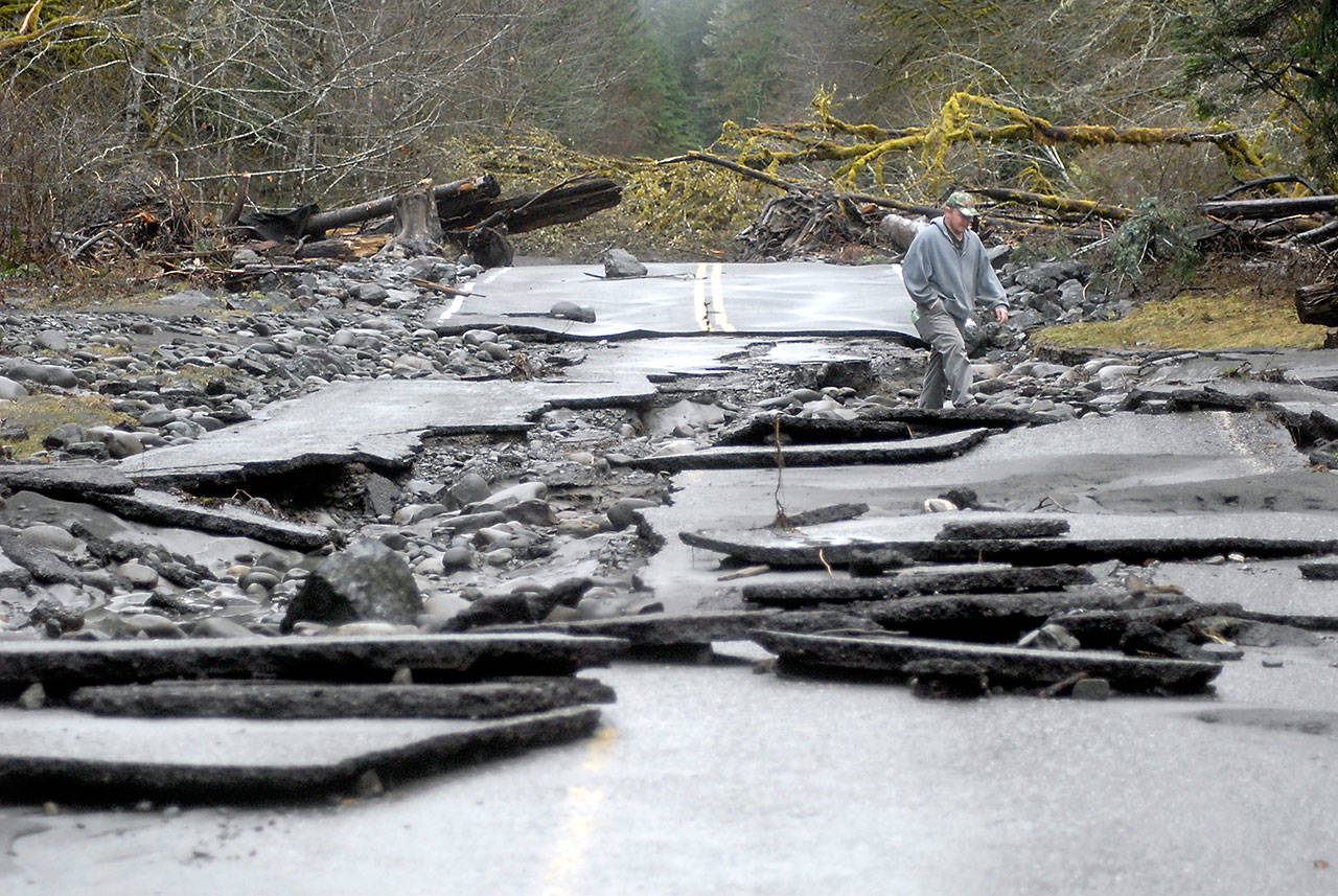 Vaughan Lester of Port Angeles picks his way through the rubble of Olympic Hot Springs Road at the site of a washout in the Elwha River Valley of Olympic National Park on Thursday. (Keith Thorpe/Peninsula Daily News)