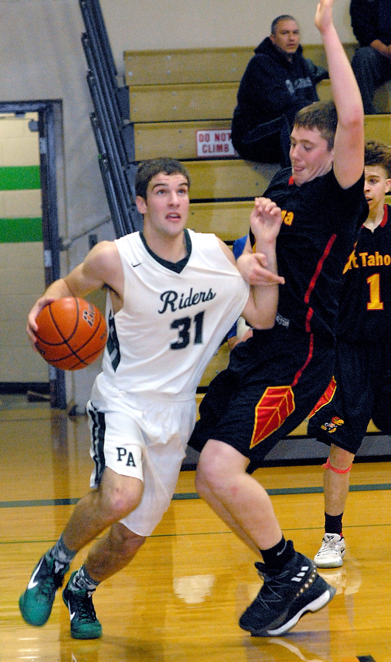 Port Angeles’ Garrett Edwards, left, drives past Mount Tahoma’s Tyler Williford in the first quarter on Friday night at Port Angeles High School. (Keith Thorpe/Peninsula Daily News)