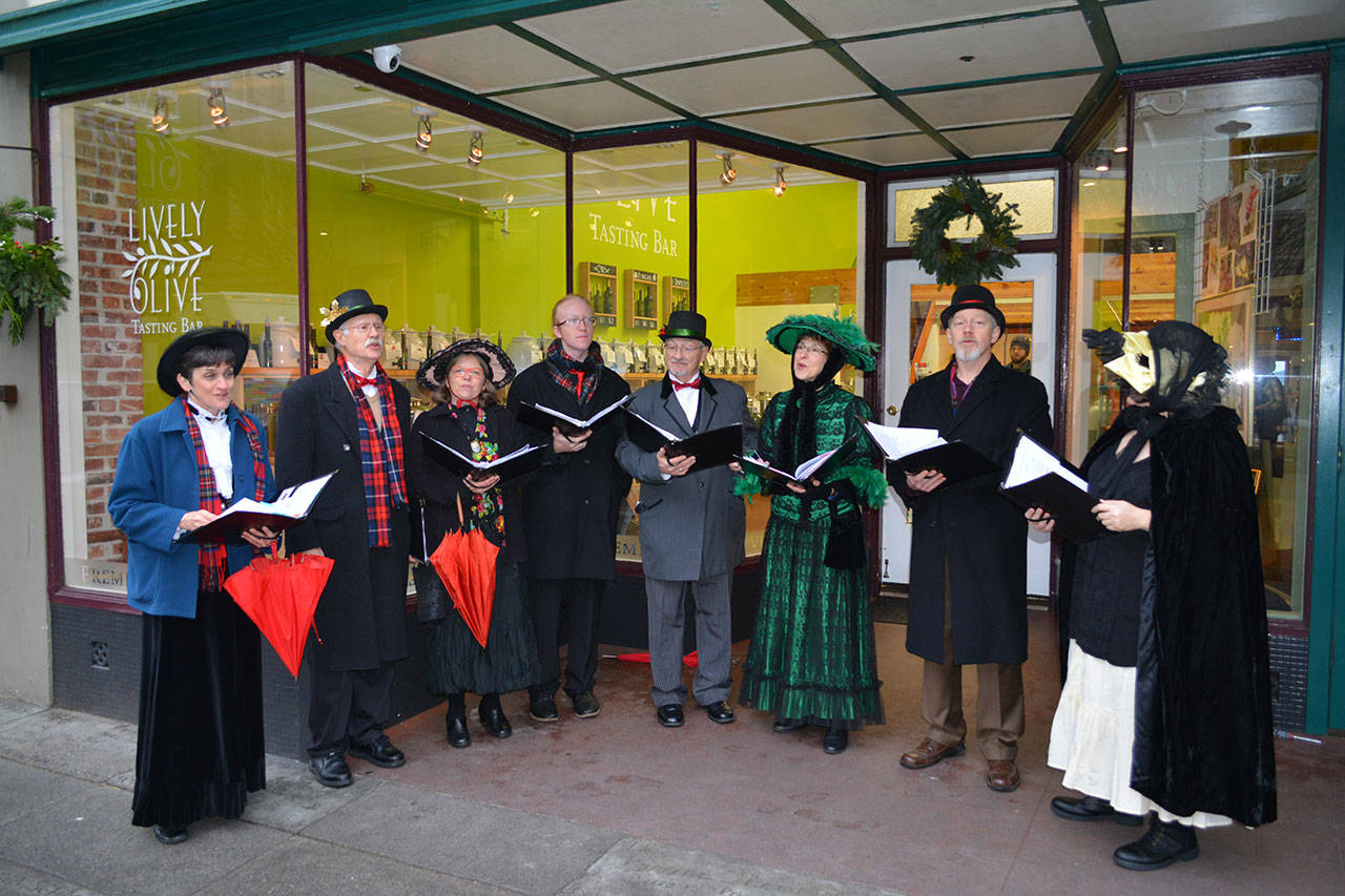 Wild Rose Chorale members sing Christmas carols on the streets of Port Townsend. The singers are, from left, Leslie Lewis, Doug Rodgers, Lynn Nowak, Orion Pendley, Al Thompson, JES Schumacher, Charles Helman and Marj Iuro. (Mark Krulish/for Peninsula Daily News)