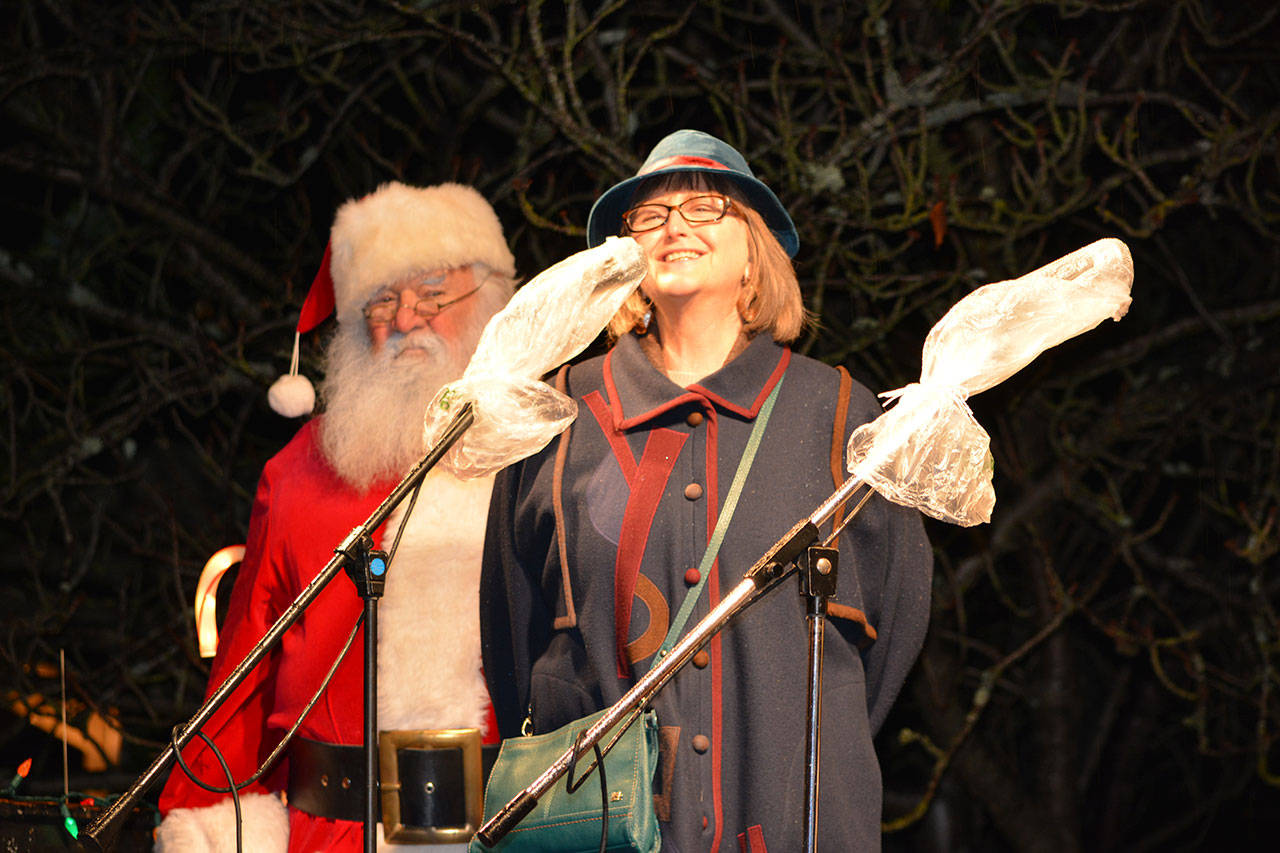 Port Townsend Mayor Deborah Stinson welcomes the crowd Saturday with Santa Claus in the background. (Mark Krulish/for Peninsula Daily News)