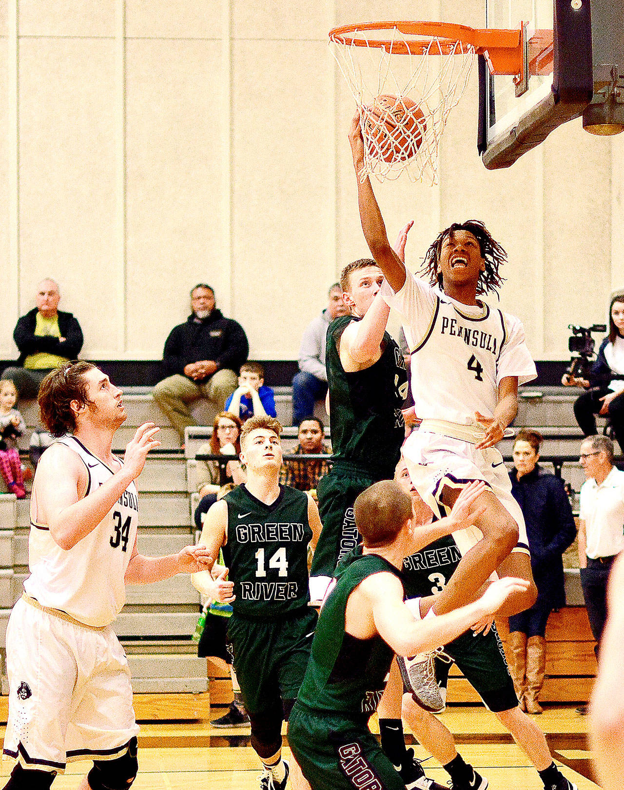 Peninsula’s Kaelin Crane goes up for a layup against Green River in Peninsula’s 82-61 win Saturday night. In on the play is Peninsula’s Marky Adams (34). (Jay Cline/for Peninsula Daily News)