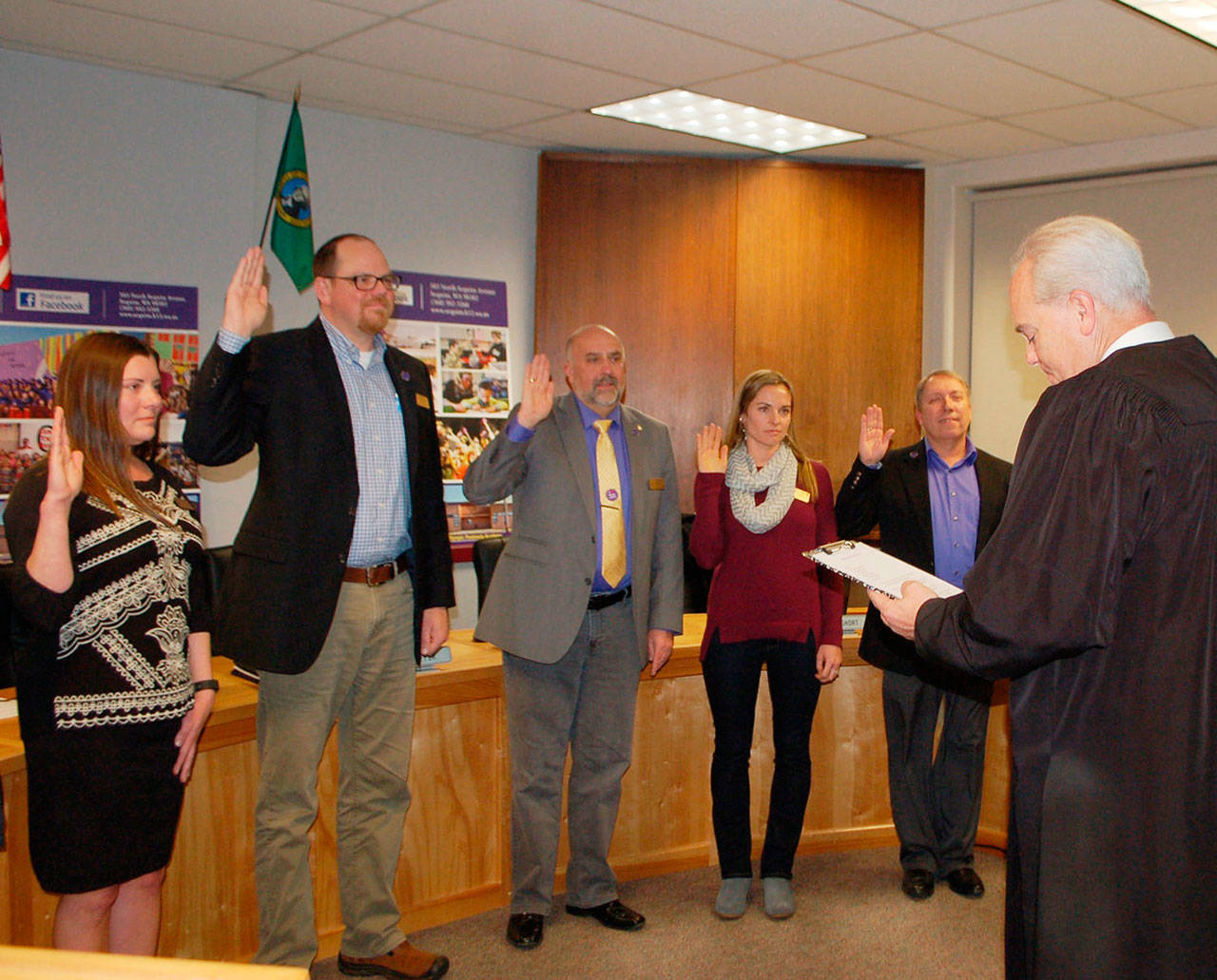 Clallam County Superior Court Judge Erik Rohrer performs an oath of office to Sequim School Board members at the Monday board meeting. From left: Heather Short, Brian Kuh, Jim Stoffer, Robin Henrikson and Brandino Gibson. (Erin Hawkins/Olympic Peninsula News Group)