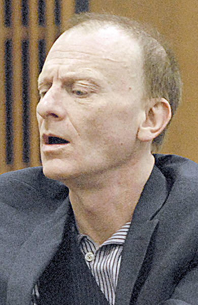 John Greystoke of Port Angeles examines a notepad during his trial for first-degree assault during an appearance in Clallam County Superior Court. (Keith Thorpe/Peninsula Daily News)