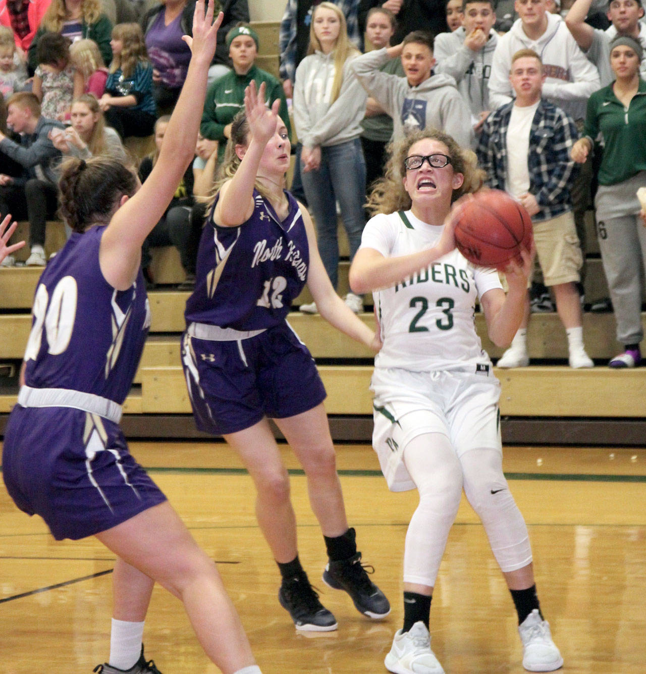 <strong>Dave Logan</strong>/for Peninsula Daily News                                Port Angeles Madison Cooke (23) pulls up for a shot while guarded by North Kitsaps Erin Pearson, left, and Grace Johnson.