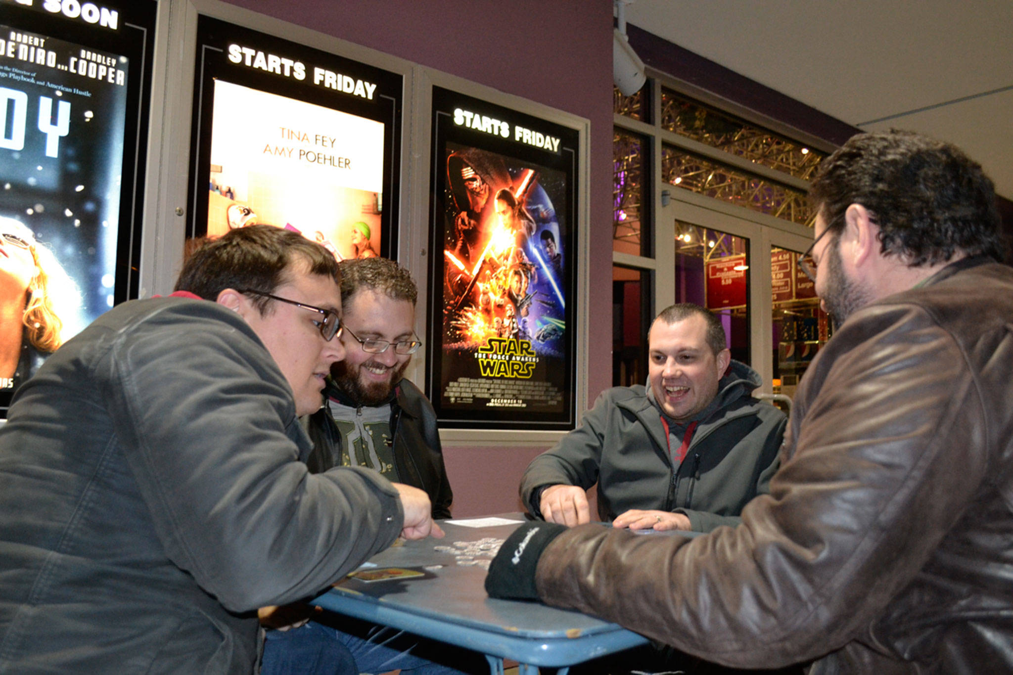 Friends, from left, Jesse Reynolds, Ryan French, Mike French and Ken Smith with Benjamin Komar (not pictured) play card games while waiting for the 3-D showing of “Star Wars: Episode VII — The Force Awakens” on opening night in 2015. Some of the sounds from the films come from animals in Sequim. (Matthew Nash /Olympic Peninsula News Group)
